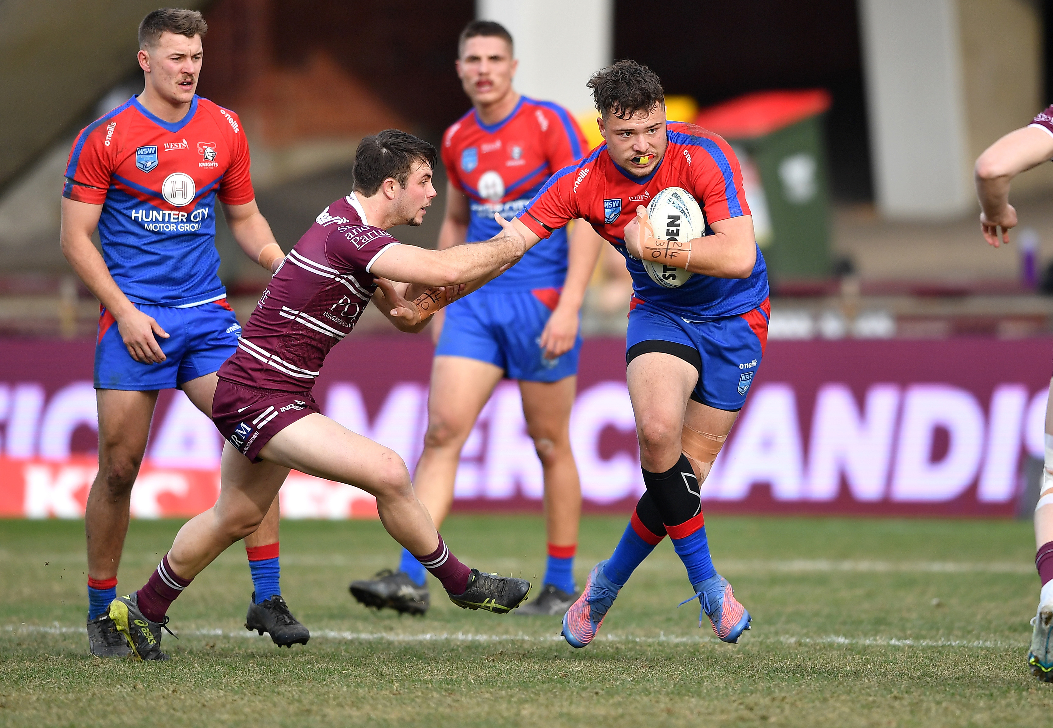 Newcastle's Ethan Ferguson breaks a Manly tackle in an under 20s game.