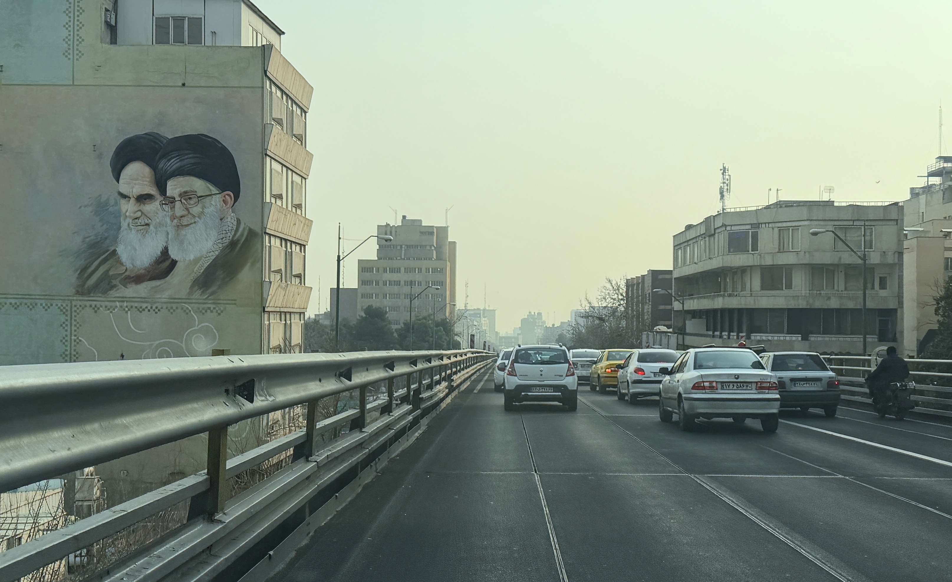 Vehicles drive past portrait of the late Iranian revolutionary founder Ayatollah Khomeini, left, and Supreme Leader Ayatollah Ali Khamenei, in downtown Tehran. the theocracy has struggled to deal with dissent in recent weeks.