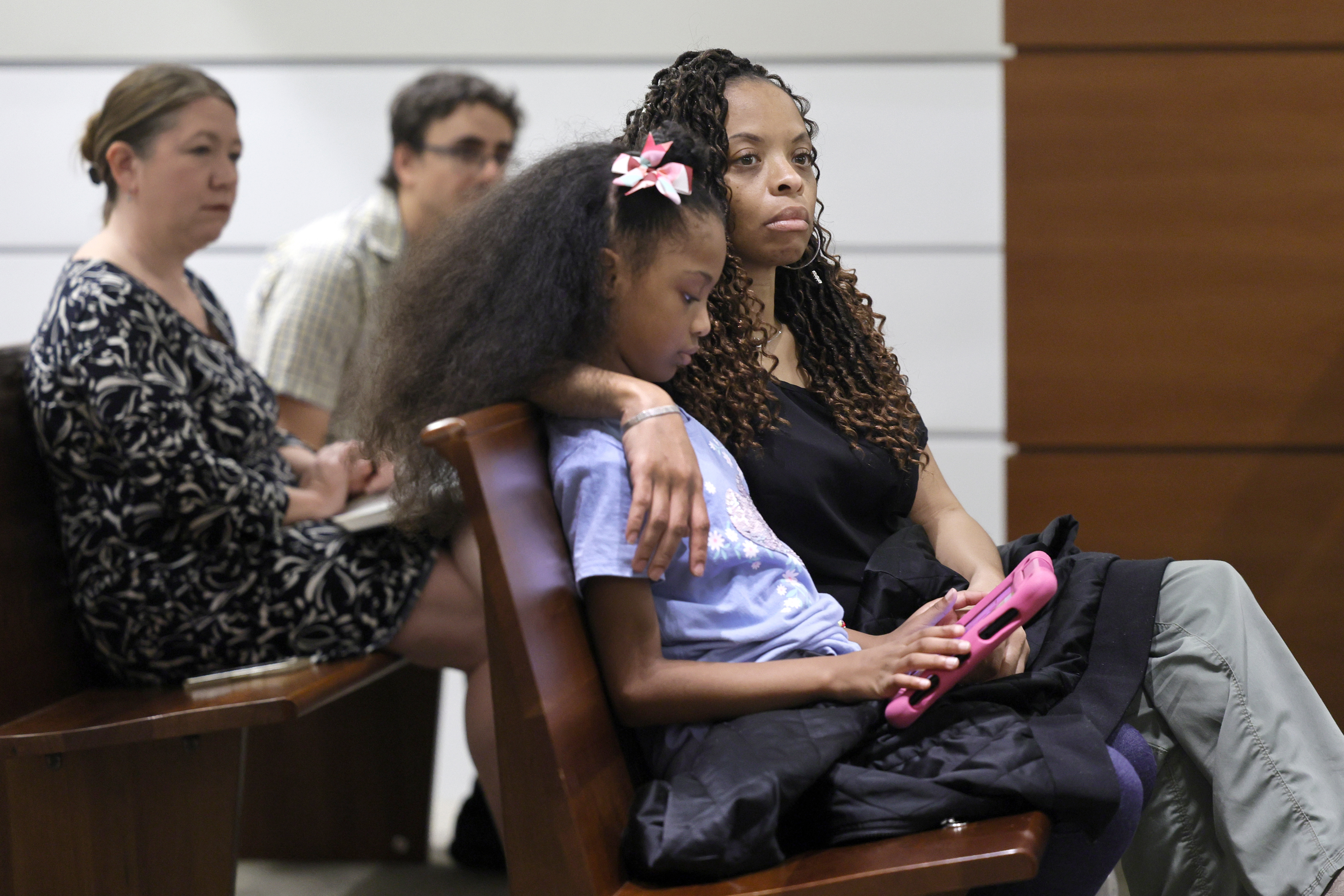 Philana Holmes y su hija Olivia Caraballo, de 7 años, escuchan al último testigo de su caso en el juzgado del condado de Broward en Fort Lauderdale, Florida, el miércoles 10 de mayo de 2023. 