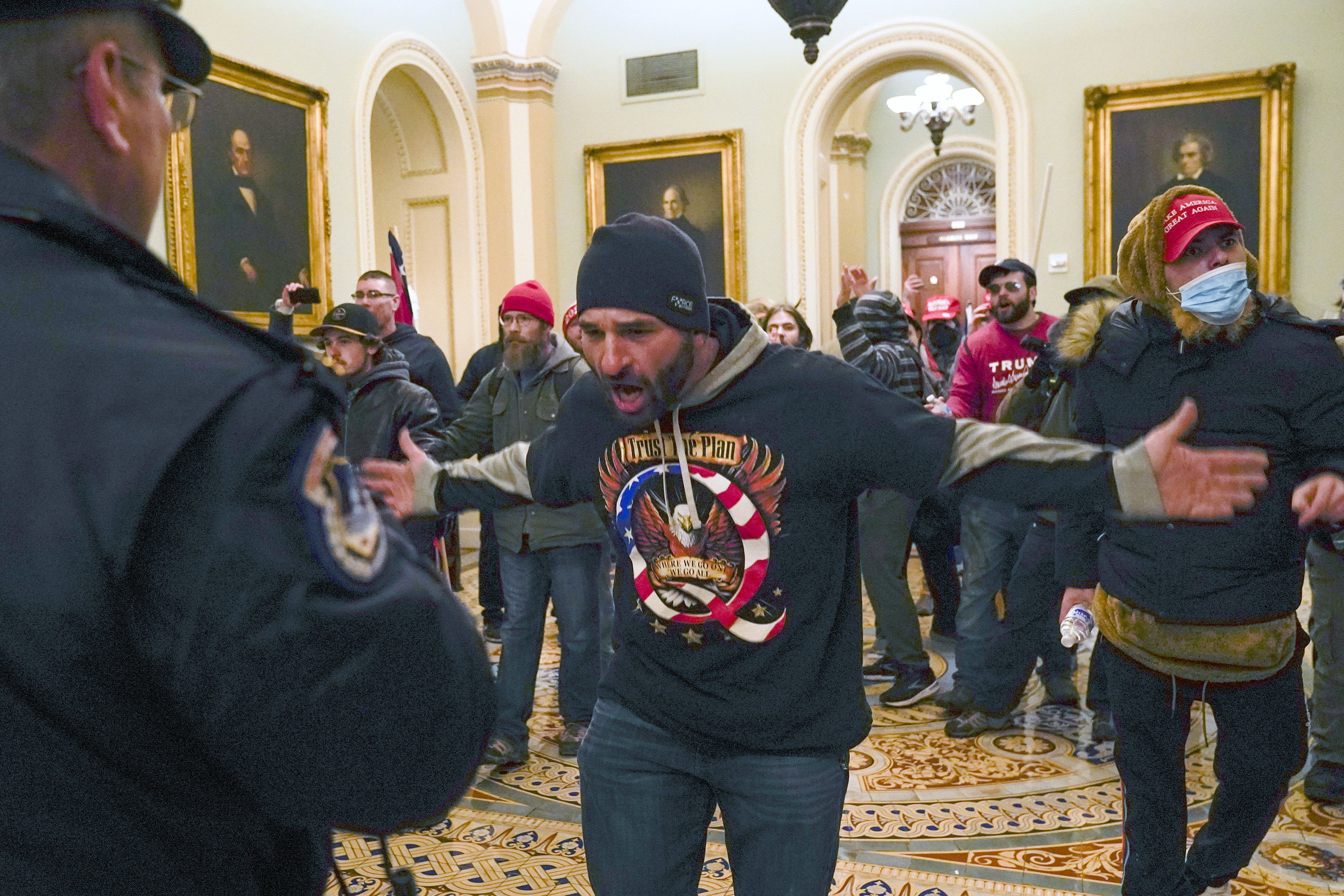 ARCHIVO - En esta foto del 6 de enero de 2021, los partidarios de Trump, incluido Douglas Jensen, centro, se enfrentan a la policía del Capitolio de EE. UU. en el pasillo fuera de la cámara del Senado en el Capitolio en Washington.  El trabajador de la construcción de Iowa y seguidor de QAnon fue sentenciado el viernes 16 de diciembre de 2022 a cinco años de prisión por su papel en la insurrección del 6 de enero de 2021.