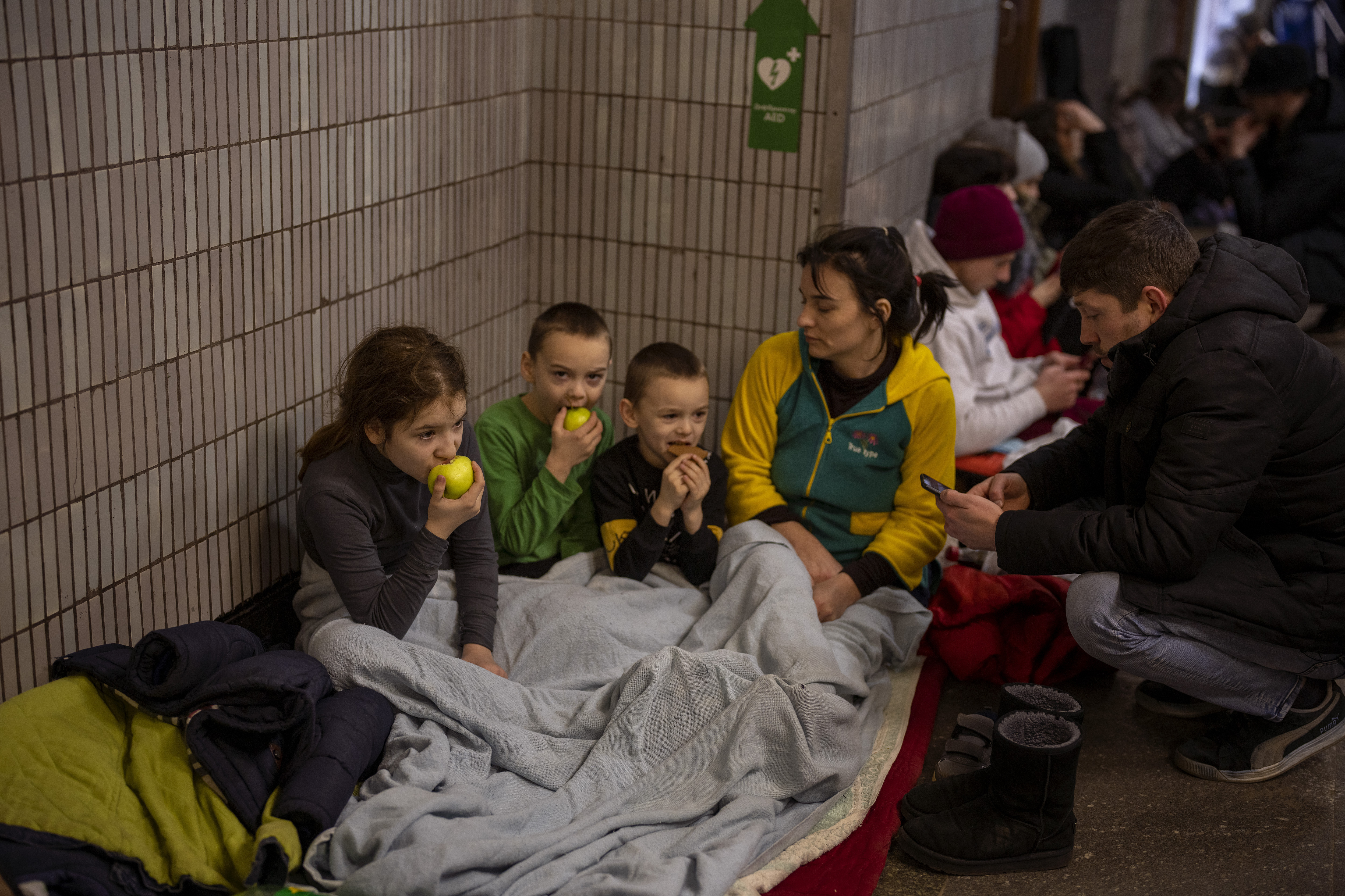 A family sit in the Kyiv subway, using it as a bomb shelter in Kyiv, Ukraine. 