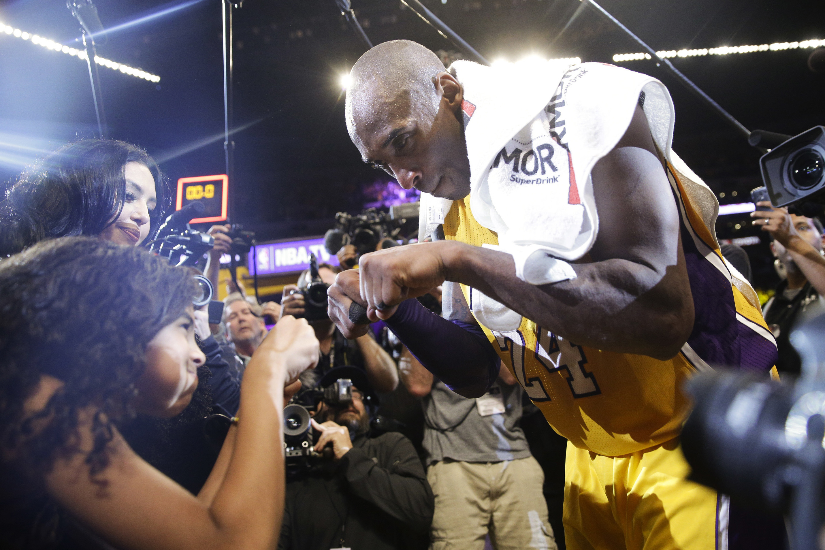 Los Angeles Lakers' Kobe Bryant fist-bumps his daughter Gianna after the last NBA basketball game of his career, in 2016.