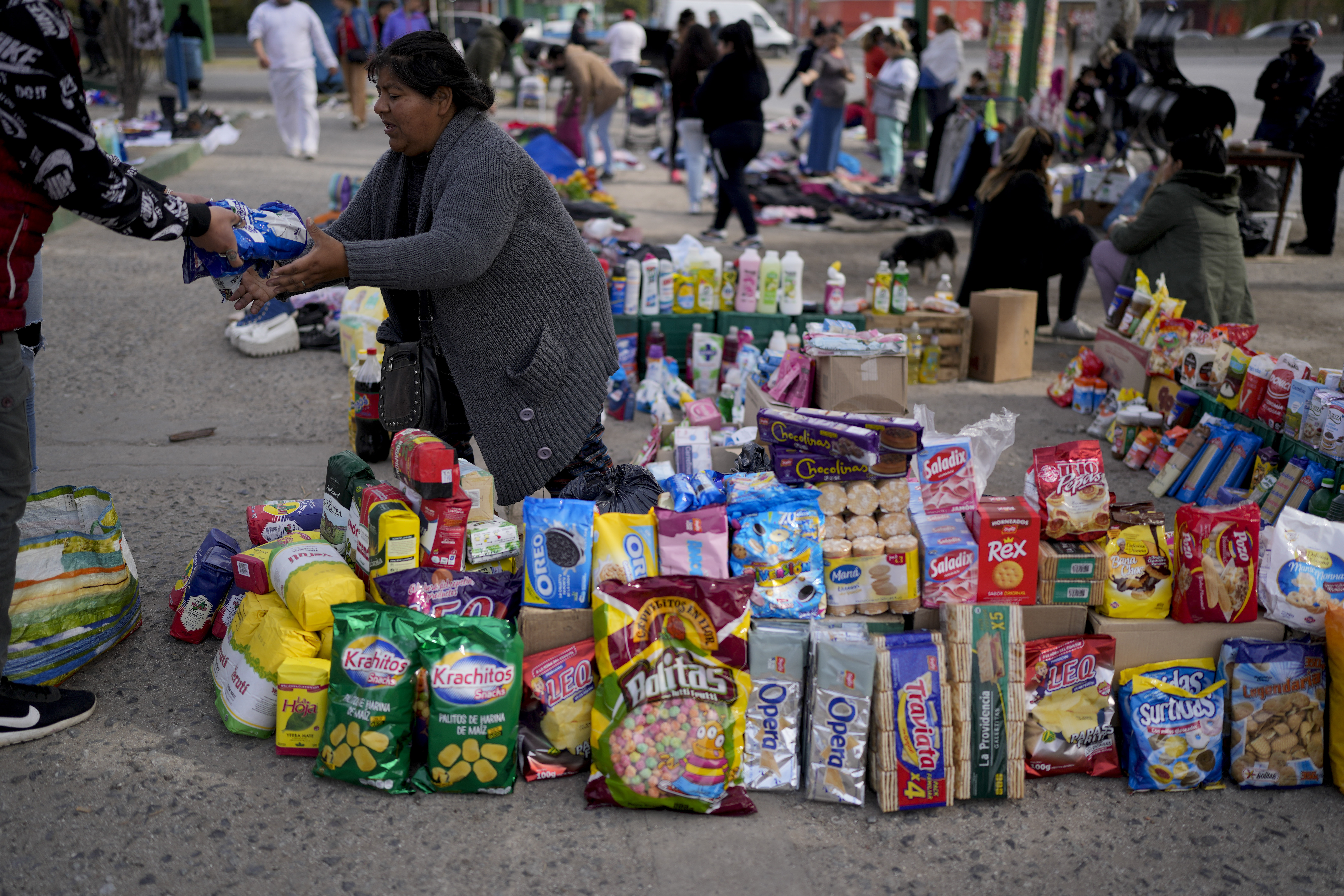 A vendor completes a transaction at a market where people can buy or barter goods, on the outskirts of Buenos Aires, Argentina, Wednesday, Aug. 10, 2022. Argentina has one of the worlds highest inflation rates, currently running at more than 60% annually, according to the National Institute of Statistics and Census of Argentina (INDEC).  (AP Photo/Natacha Pisarenko)