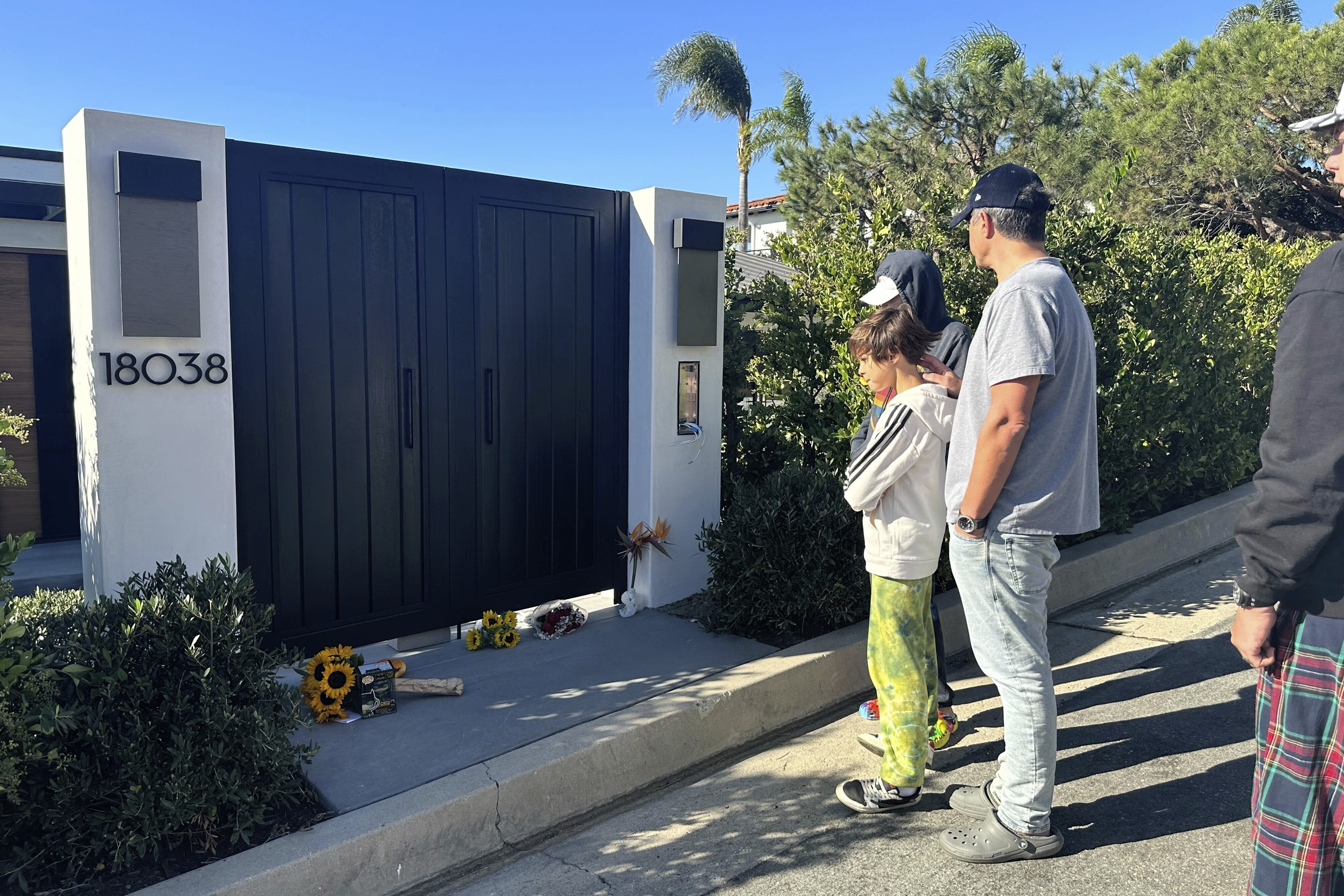 Los dolientes se encuentran afuera de la casa del actor Matthew Perry, el domingo 29 de octubre de 2023, en el área de Pacific Palisades de Los Ángeles. 