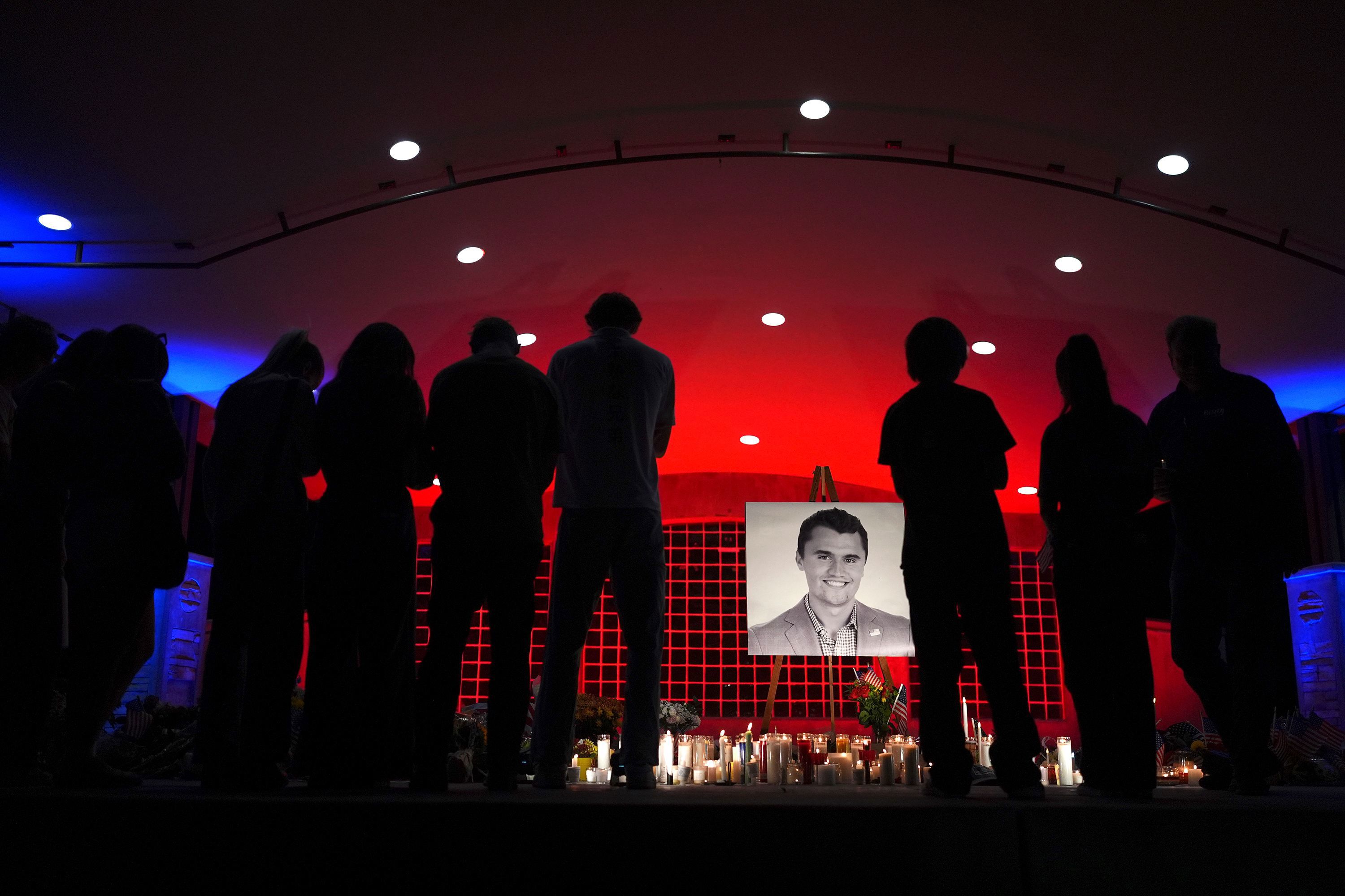 People look at a photo of Charlie Kirk, the CEO and co-founder of Turning Point USA, who was shot and killed, at a vigil in his memory, on September 11, 2025, in Orem, Utah.