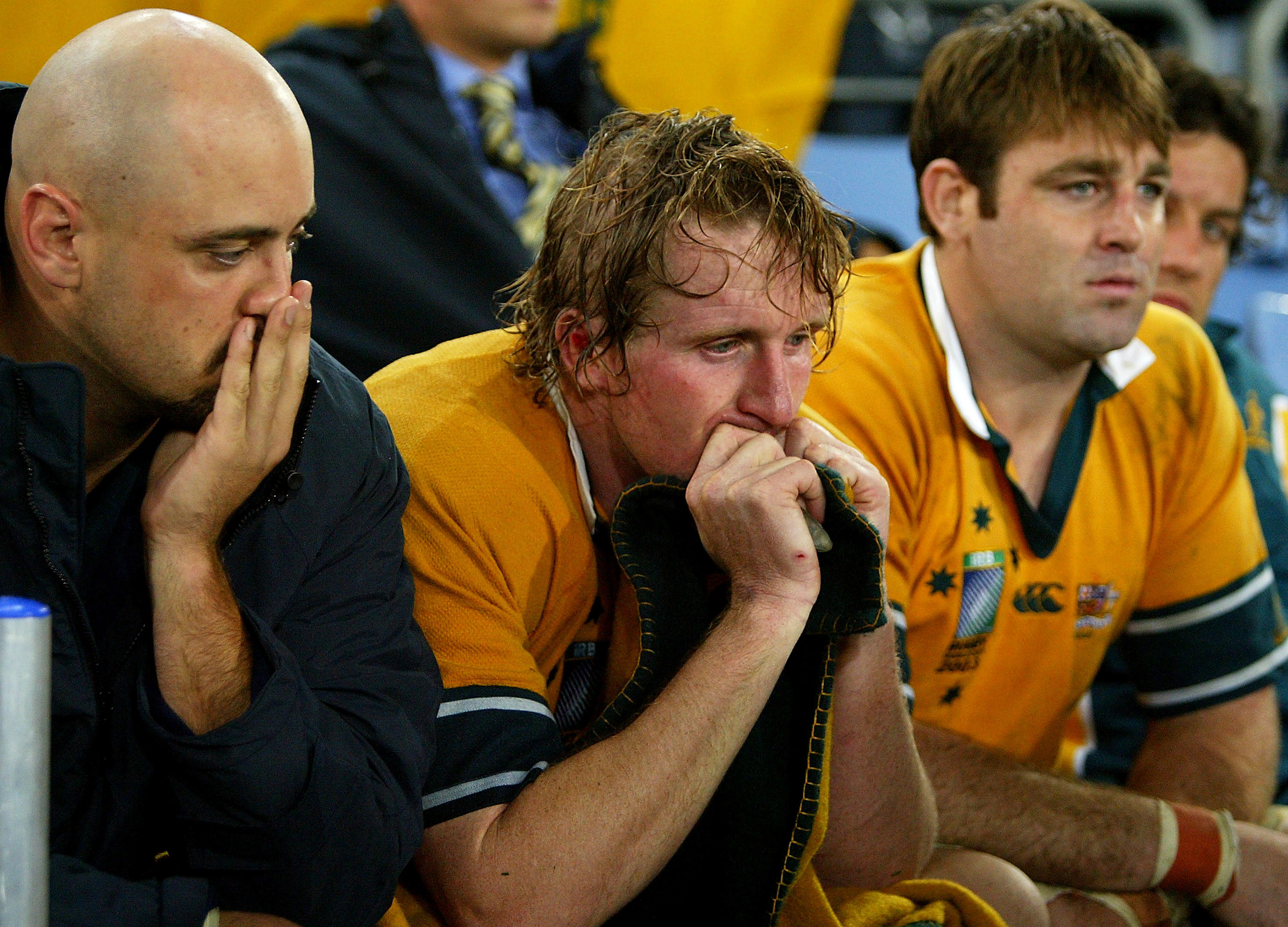 Dejected Wallabies Nathan Sharpe, Bill Young and David Lyons watch England celebrate in 2003.