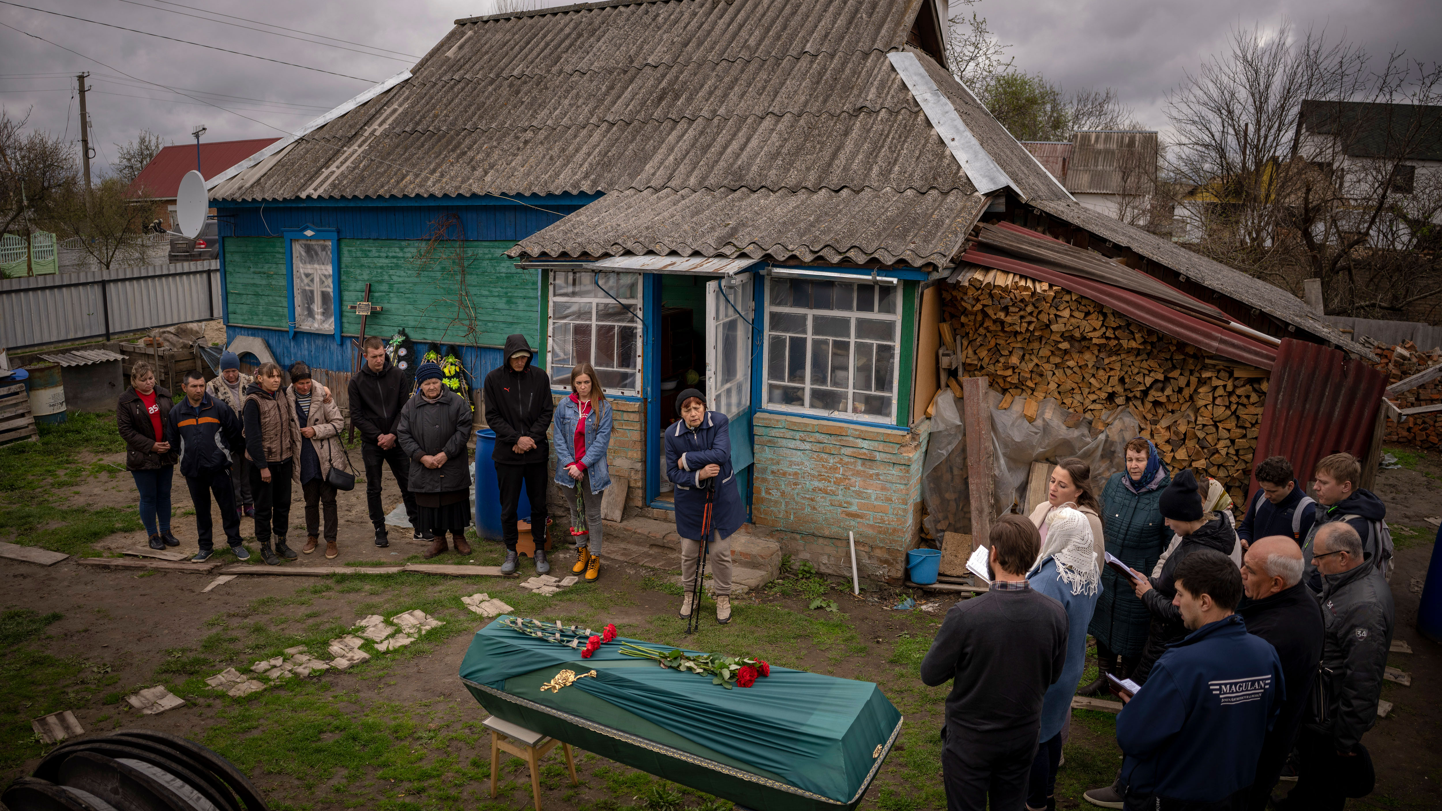 Friends and neighbours of Mykola "Kolia" Moroz, 47, gather during a funeral service at his home in the Ukrainian village of Ozera, near Bucha, on Tuesday, April 26, 2022.