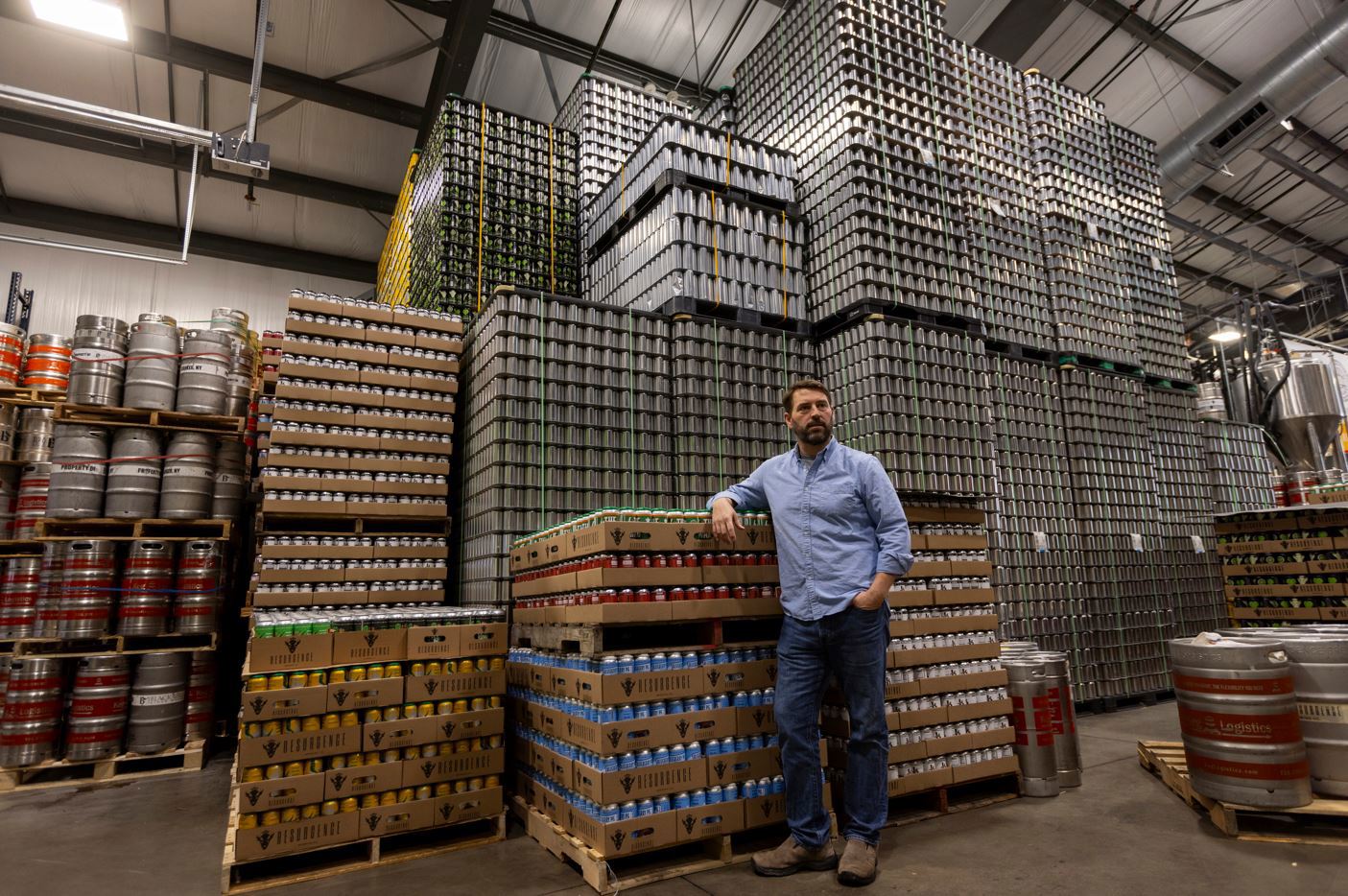 Jeff Ware, presidente de Resurgence Brewing Company, posa para un retrato cerca de un almacenamiento de latas de aluminio, que provienen de Canadá.