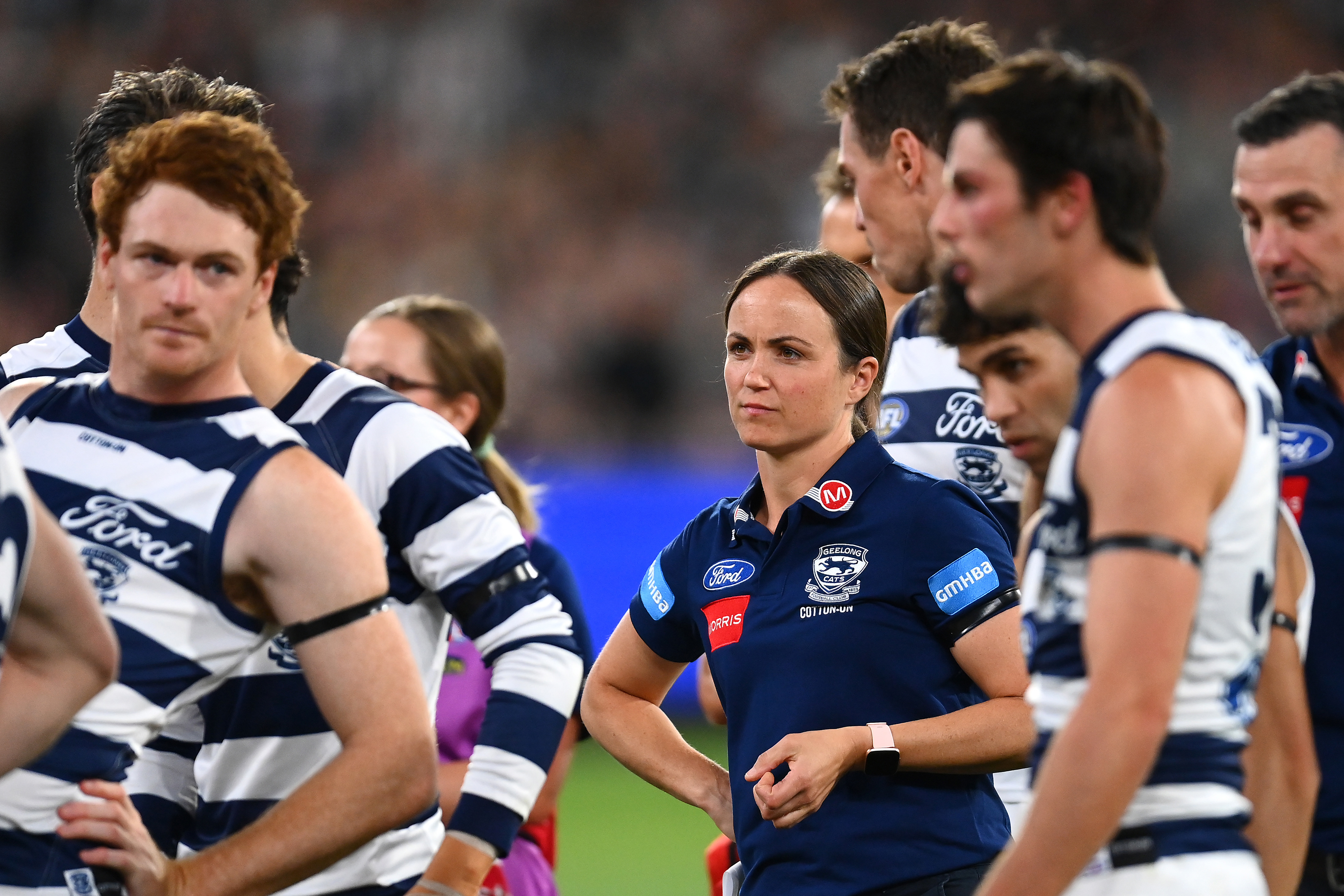 MELBOURNE, AUSTRALIA - MARCH 17: Daisy Pearce looks on as Cats head coach Chris Scott speaks to his players during the round one AFL match between Geelong Cats and Collingwood Magpies at Melbourne Cricket Ground, on March 17, 2023, in Melbourne, Australia. (Photo by Quinn Rooney/Getty Images)