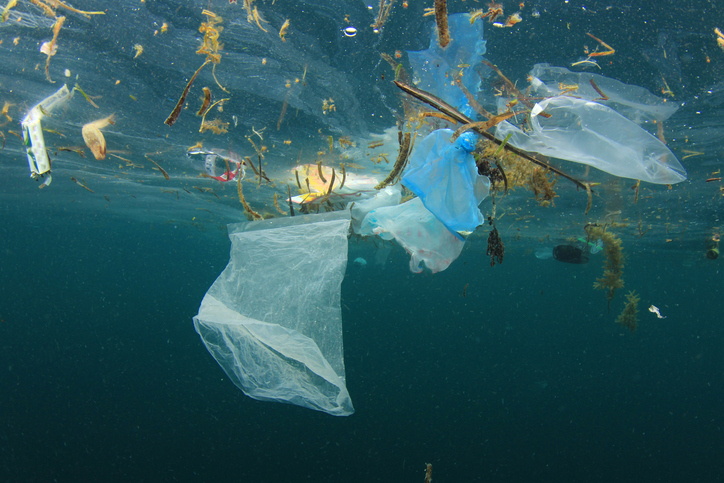 Plastic bags, bottles, straws, cups and other garbage pollute the sea. Underwater photo of trash dumped into sea instead of recycling.