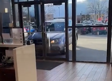 Moments before the Subaru Outback collides into the office space of the dealership.