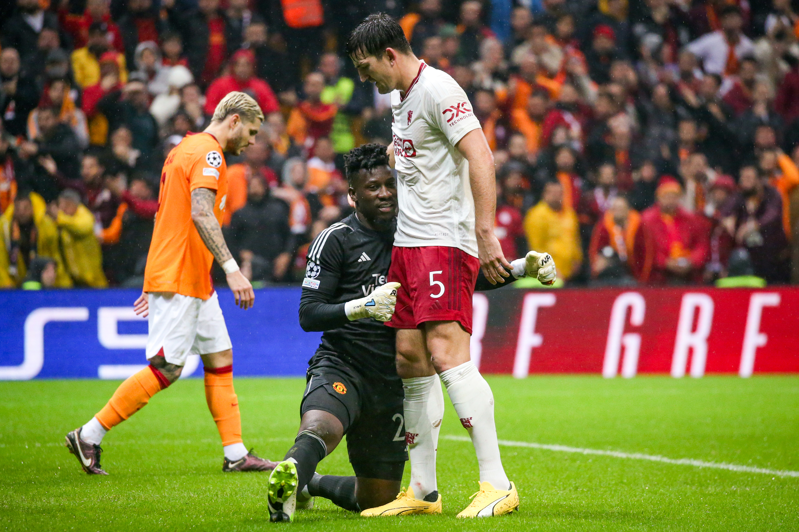 Andre Onana of Manchester United interacts with Harry Maguire.