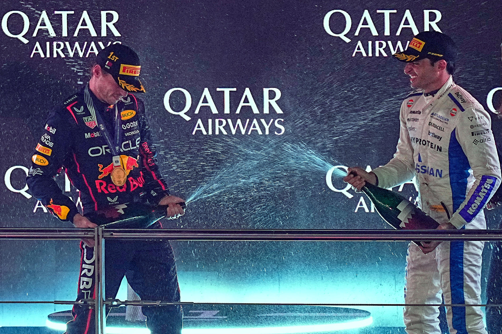 Winner Red Bull driver Max Verstappen of the Netherlands, left, and third placed Williams driver Carlos Sainz of Spain celebrate on the podium after the Qatar Formula One Grand Prix, in Lusail, Qatar, Sunday, Nov. 30, 2025.(AP Photo/Fatima Shbair)