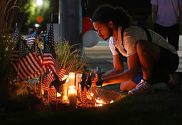 Man arranges candle at vigil for Charlie Kirk outside Timpanogos Regional Hospital (Lindsey Wasson/AP)