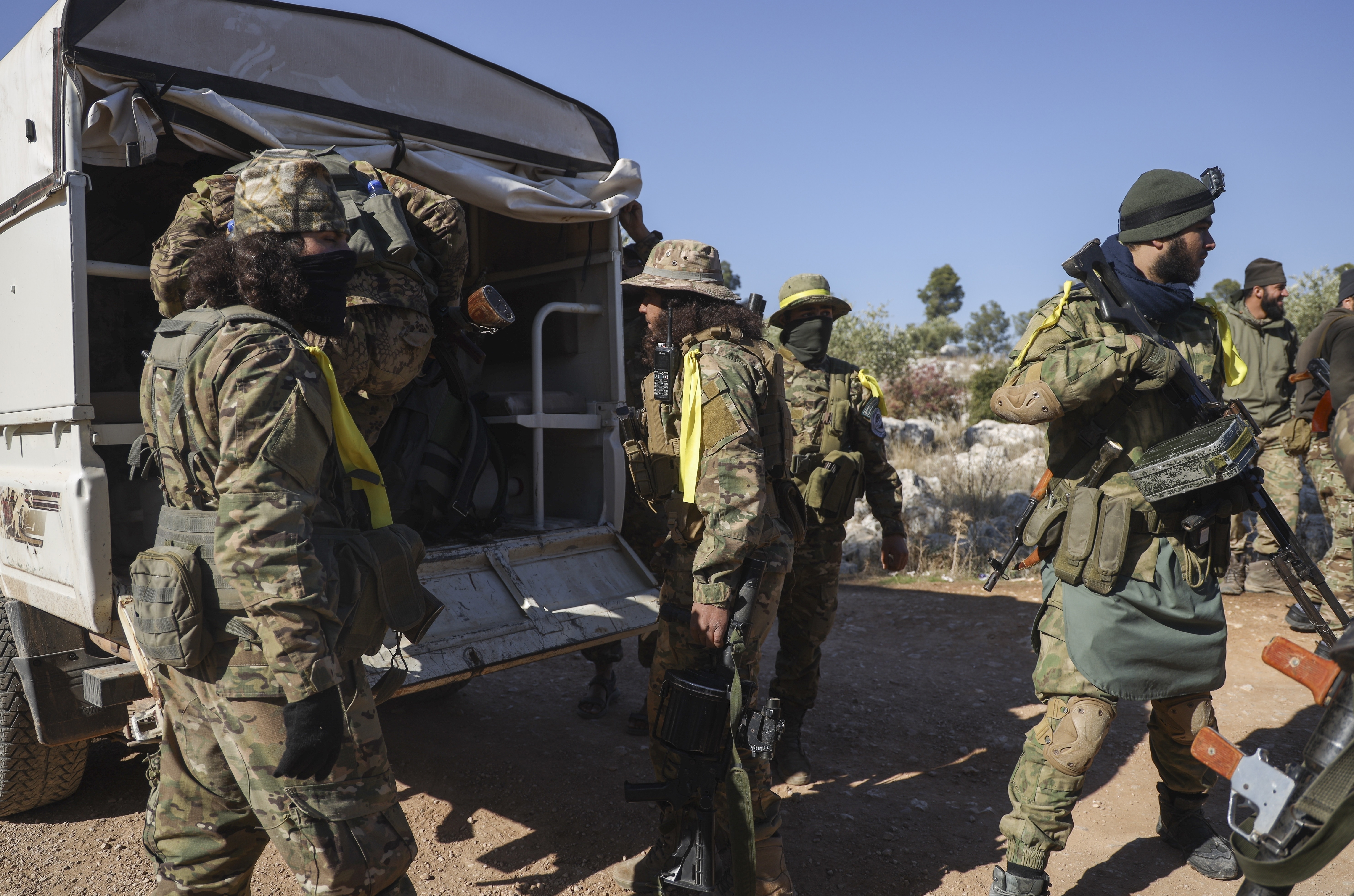 Los combatientes de la oposición siria se bajan de un camión cuando ingresan a la aldea de Anjara, en las afueras del oeste de Alepo, Siria, el jueves 28 de noviembre de 2024, como parte de su principal ofensiva contra áreas controladas por el gobierno en el noroeste de Siria. (Foto AP/Omar Albam)