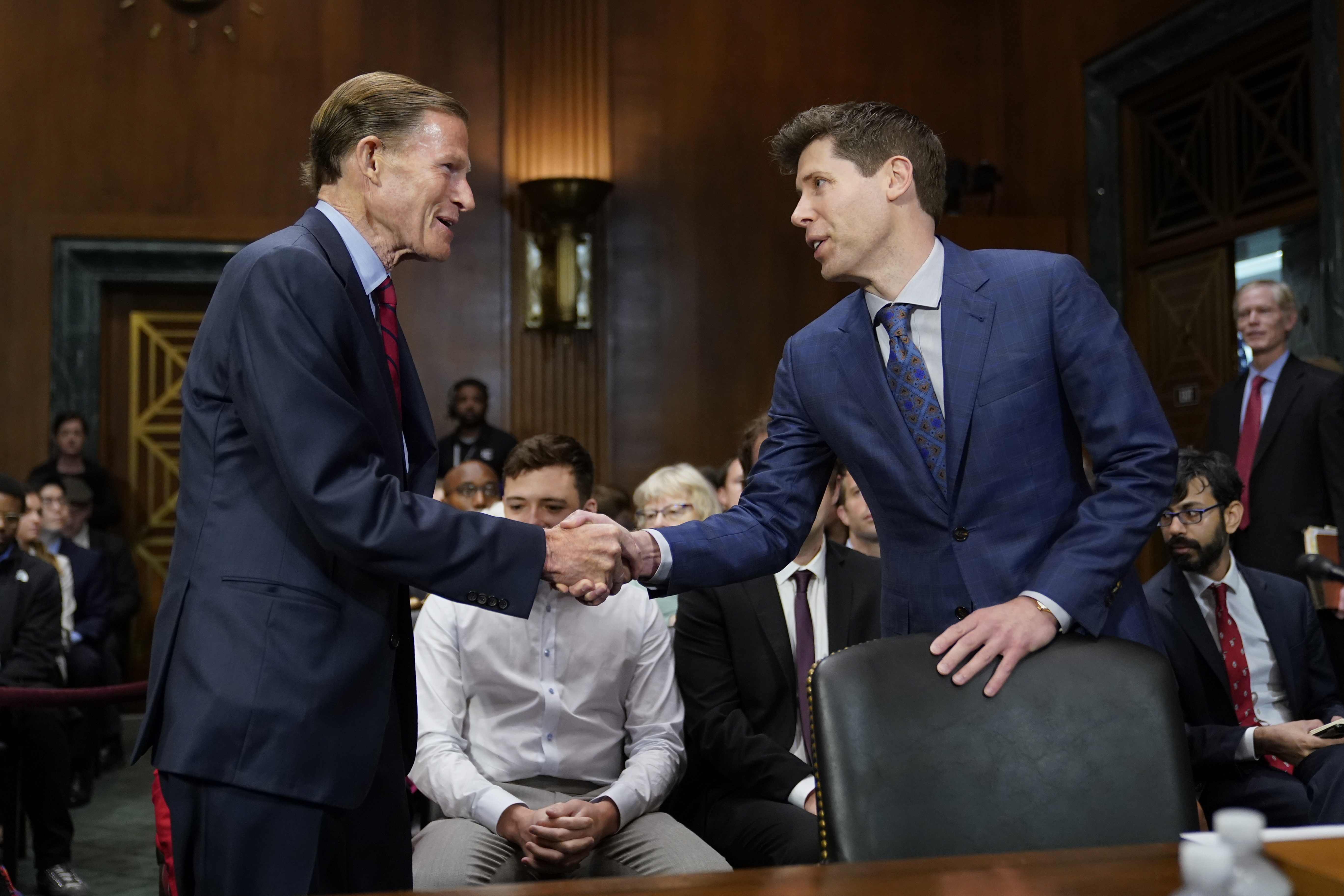 Sen. Richard Blumenthal, D-Conn., left, chair of the Senate Judiciary Subcommittee on Privacy, Technology and the Law, greets OpenAI CEO Sam Altman before a hearing on artificial intelligence, Tuesday, May 16, 2023, on Capitol Hill in Washington.