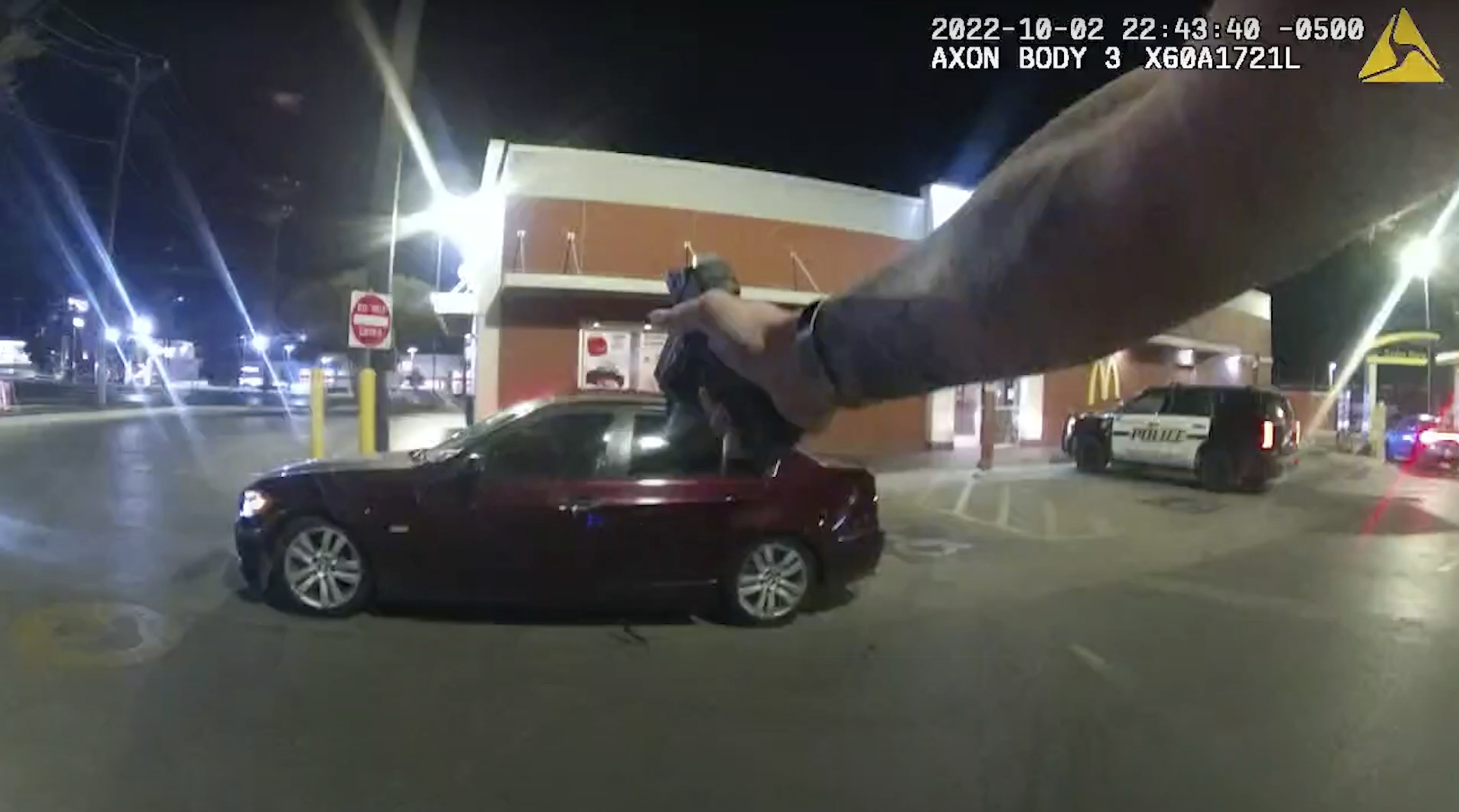 In this image taken from Oct. 2, 2022 police body camera video and released by San Antonio Police Department, Erik Cantu drives away as San Antonio Police officer James Brennand shoots his pistol at the car in a fast food restaurant parking lot in San Antonio, Texas. 