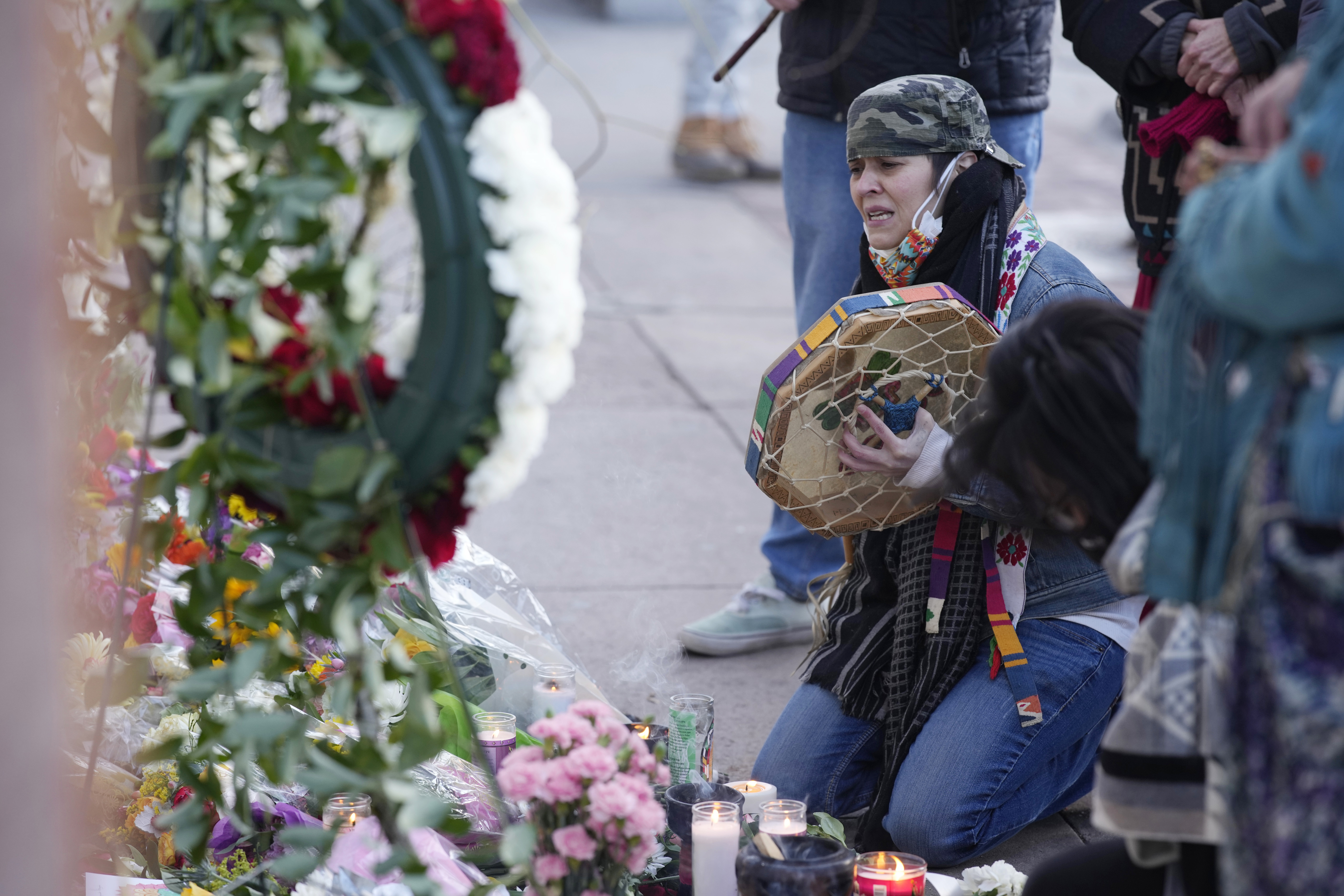 Mourners gathered outside the door of the tattoo parlour in Denver, which was one of the scenes of the shooting. 