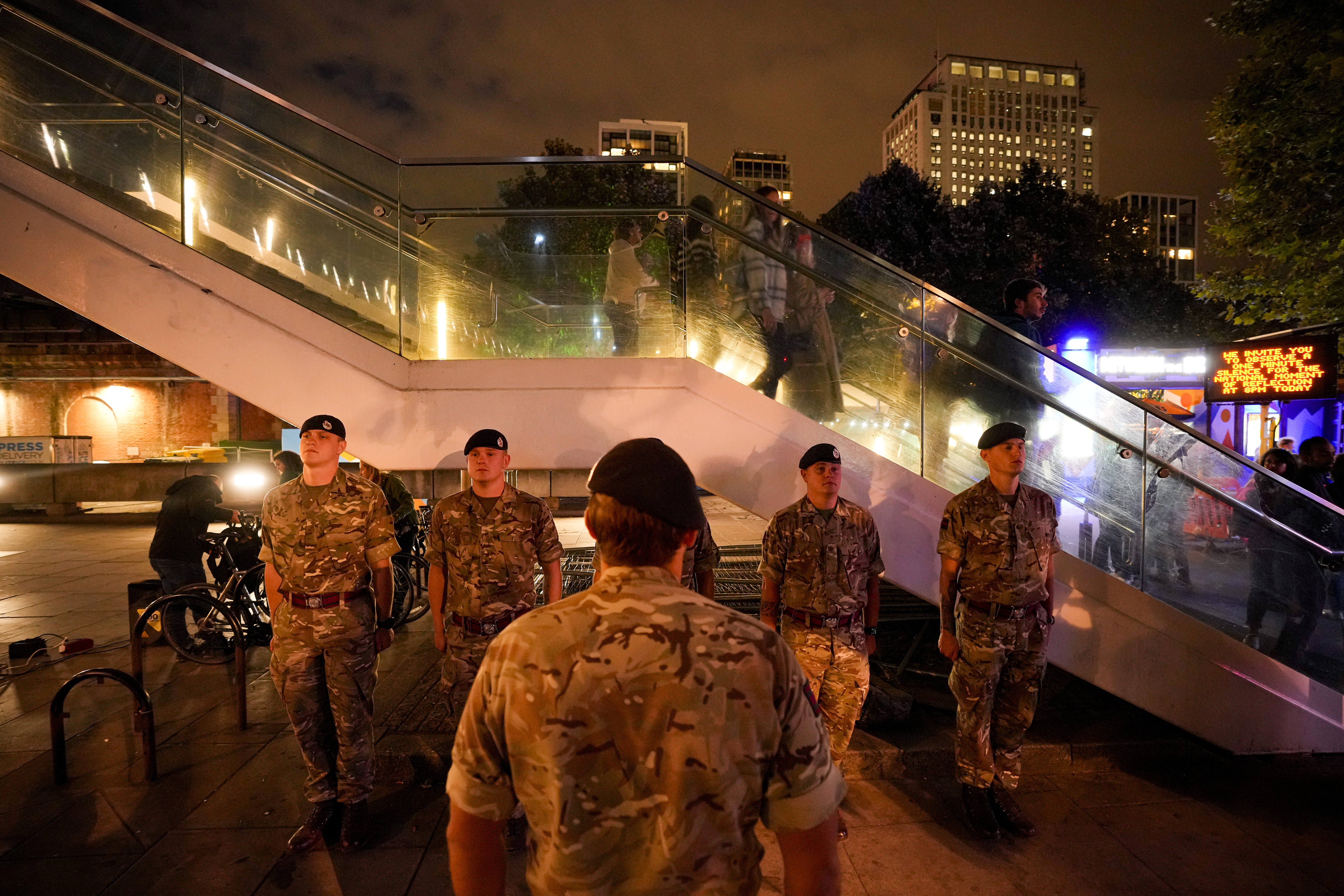 British servicemen observe a "National moment of reflection" in honour of the late Queen Elizabeth II, the day before her funeral, in London, Sunday, Sept. 18, 2022. 