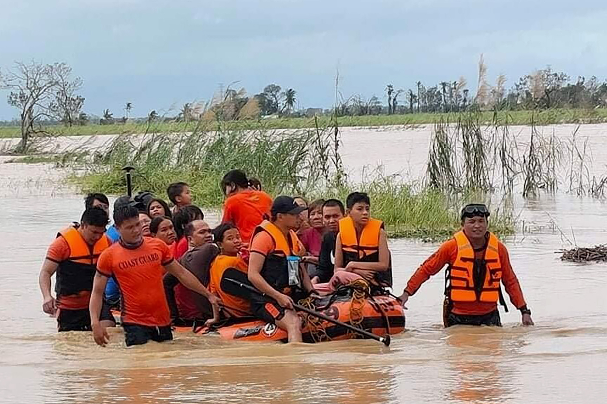 In this handout photo provided by the Philippine Coast Guard, rescuers pull a rubber boat as they assist residents who were trapped in their homes after floodwaters caused by Typhoon Rai inundated their village in Loboc, Bohol, central Philippines on Friday, Dec. 17, 2021. 