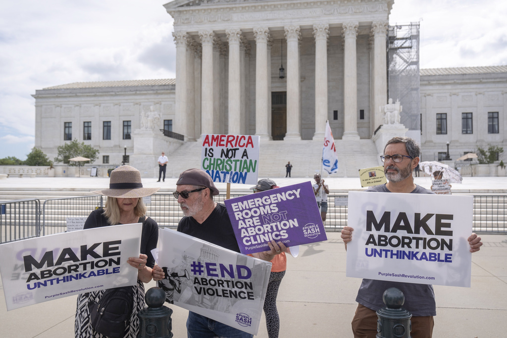 ARCHIVO - Katie Mahoney, izquierda, y el reverendo Patrick Mahoney, director de estrategia de Stanton Healthcare, un centro de embarazo con sede en Idaho que no ofrece abortos, leen el texto de una decisión de la Corte Suprema frente a la Corte Suprema el jueves 27 de junio. 2024, en Washington. (Foto AP/Mark Schiefelbein, Archivo)