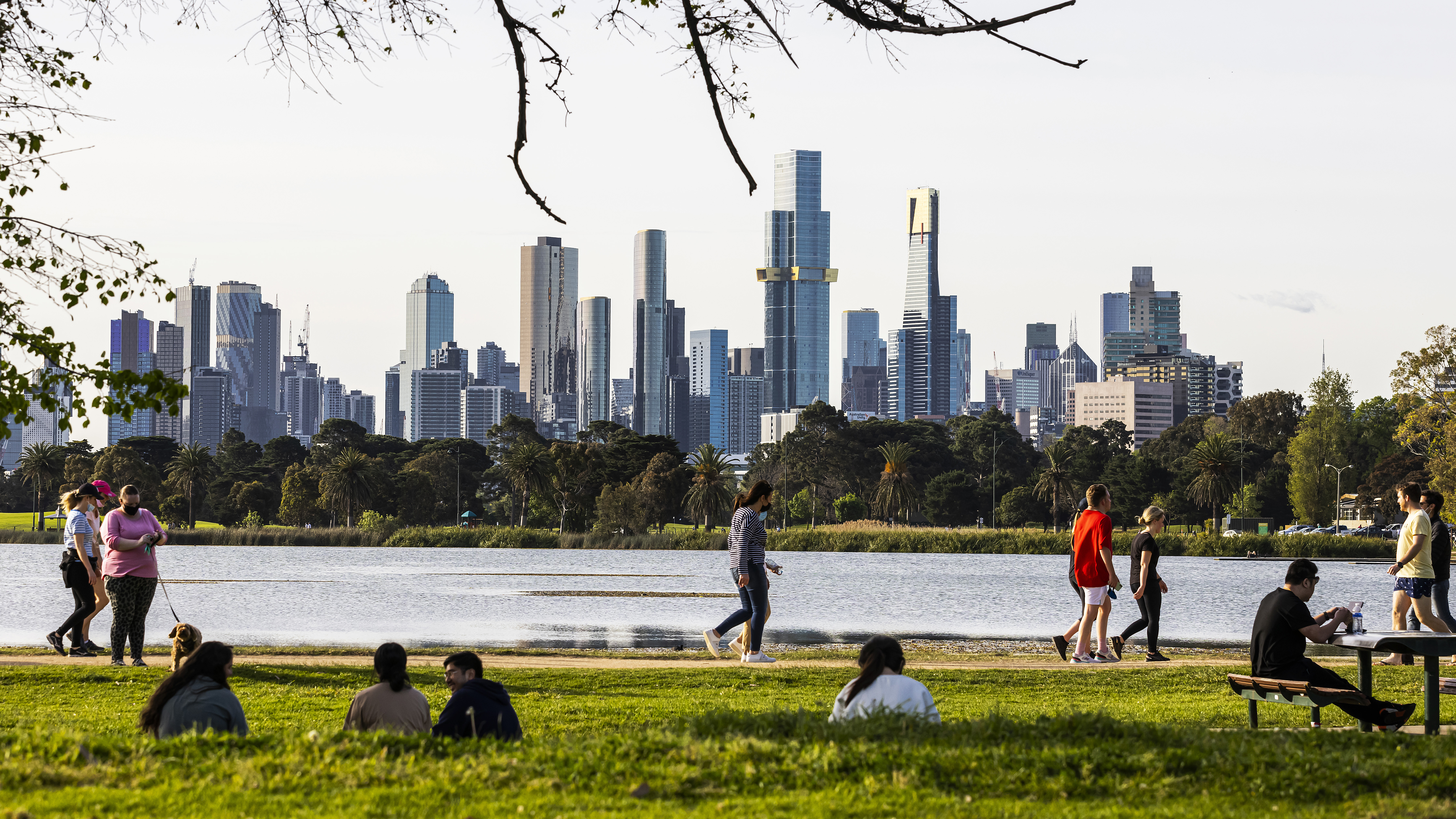 People exercising and picnicking at Albert Park Lake in Melbourne.