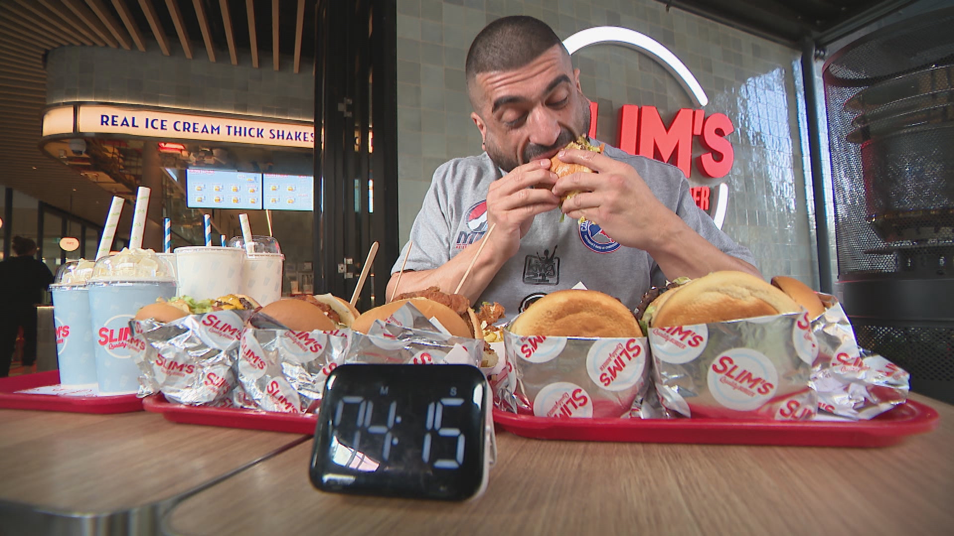 El comedor profesional James Webb entrena para la competencia de perritos calientes en Coney Island comiendo hamburguesas.