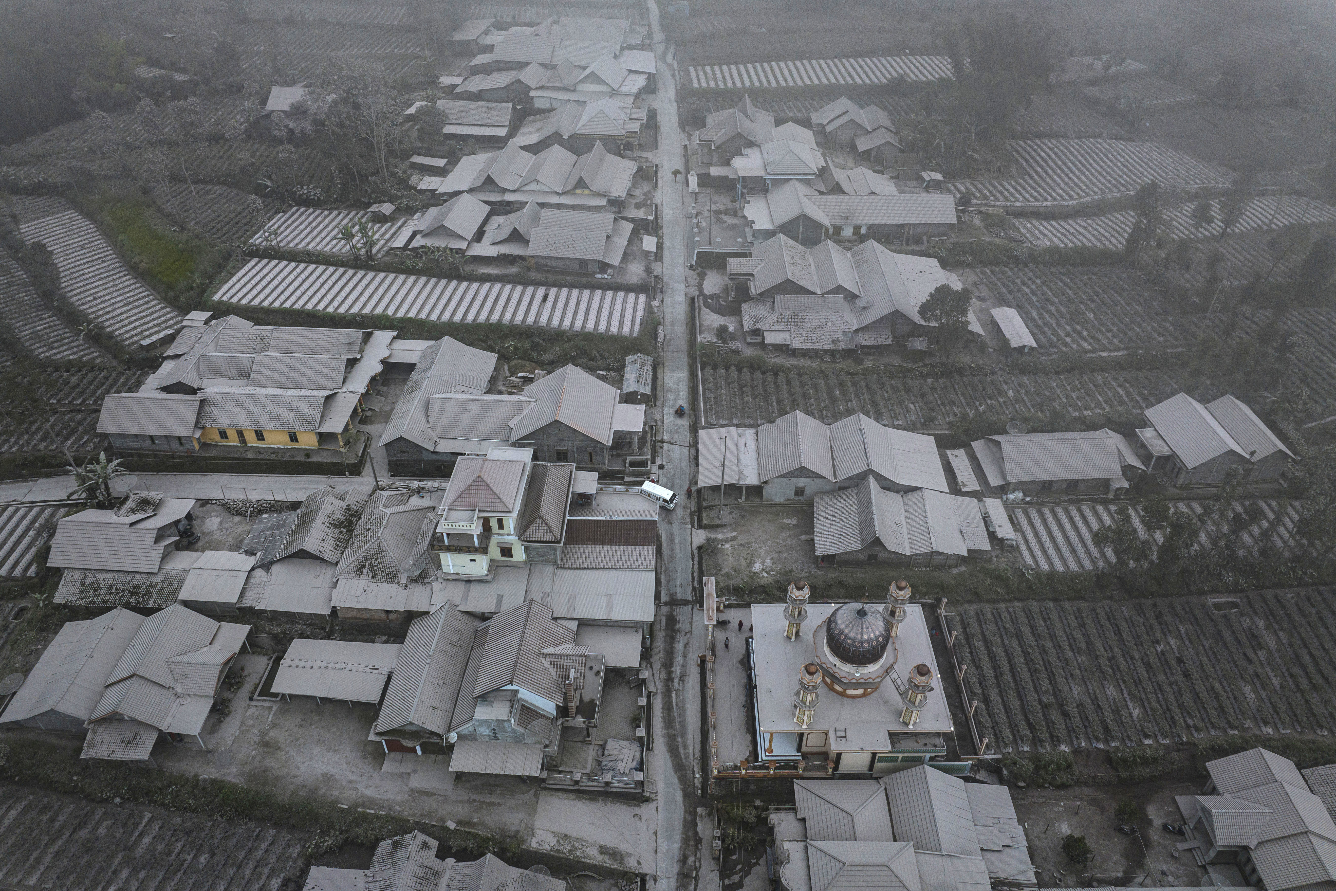 An aerial view of houses covered by ash after Mount Merapi erupted spewing volcanic materials at Stabelan village on March 11, 2023 in Boyolali, Central Java, Indonesia. Mount Merapi, 2,968 metres high, is known as one of the most active volcanoes in Indonesia, with an eruption occurring every two to five years. 