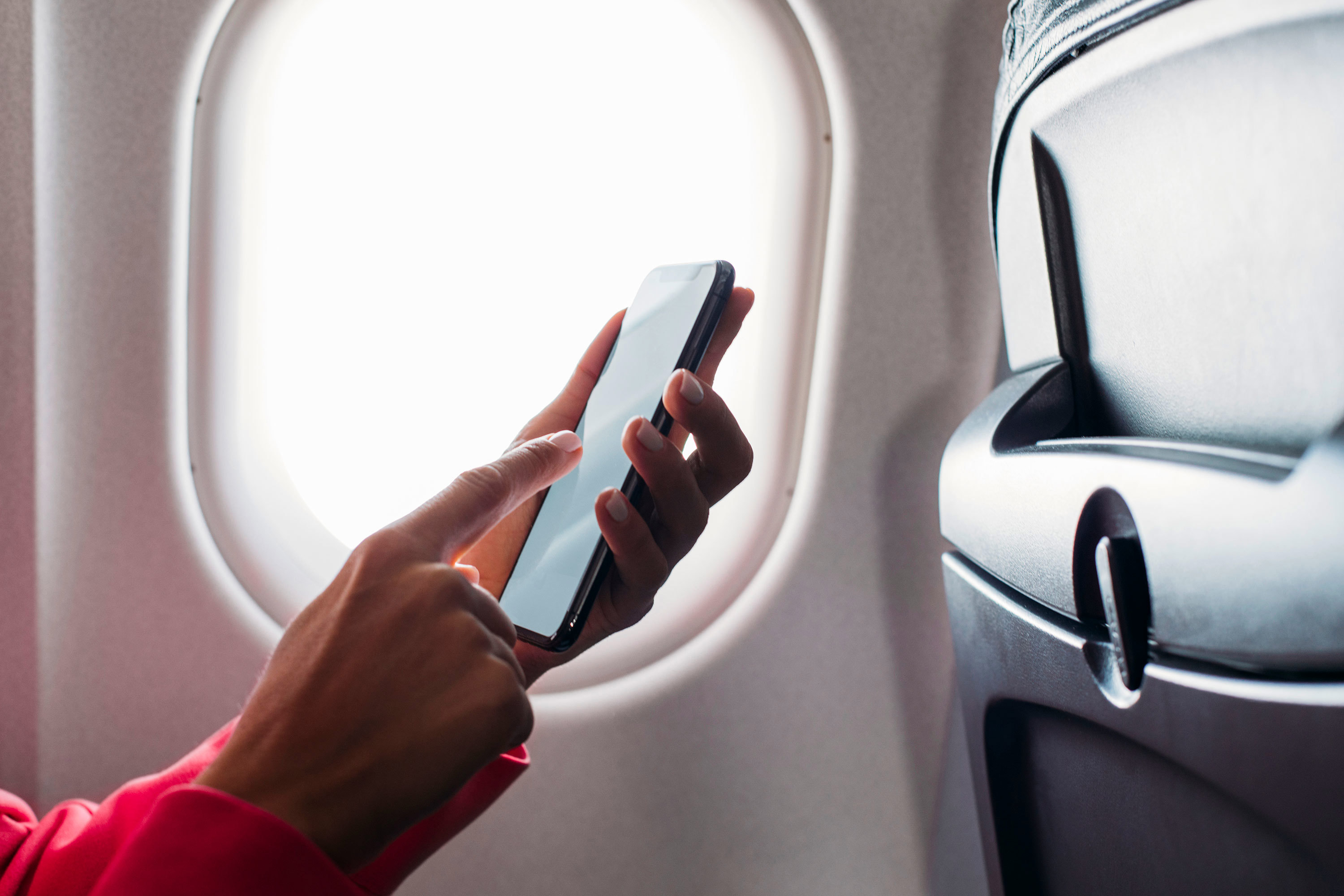Mujer usando teléfono en avión