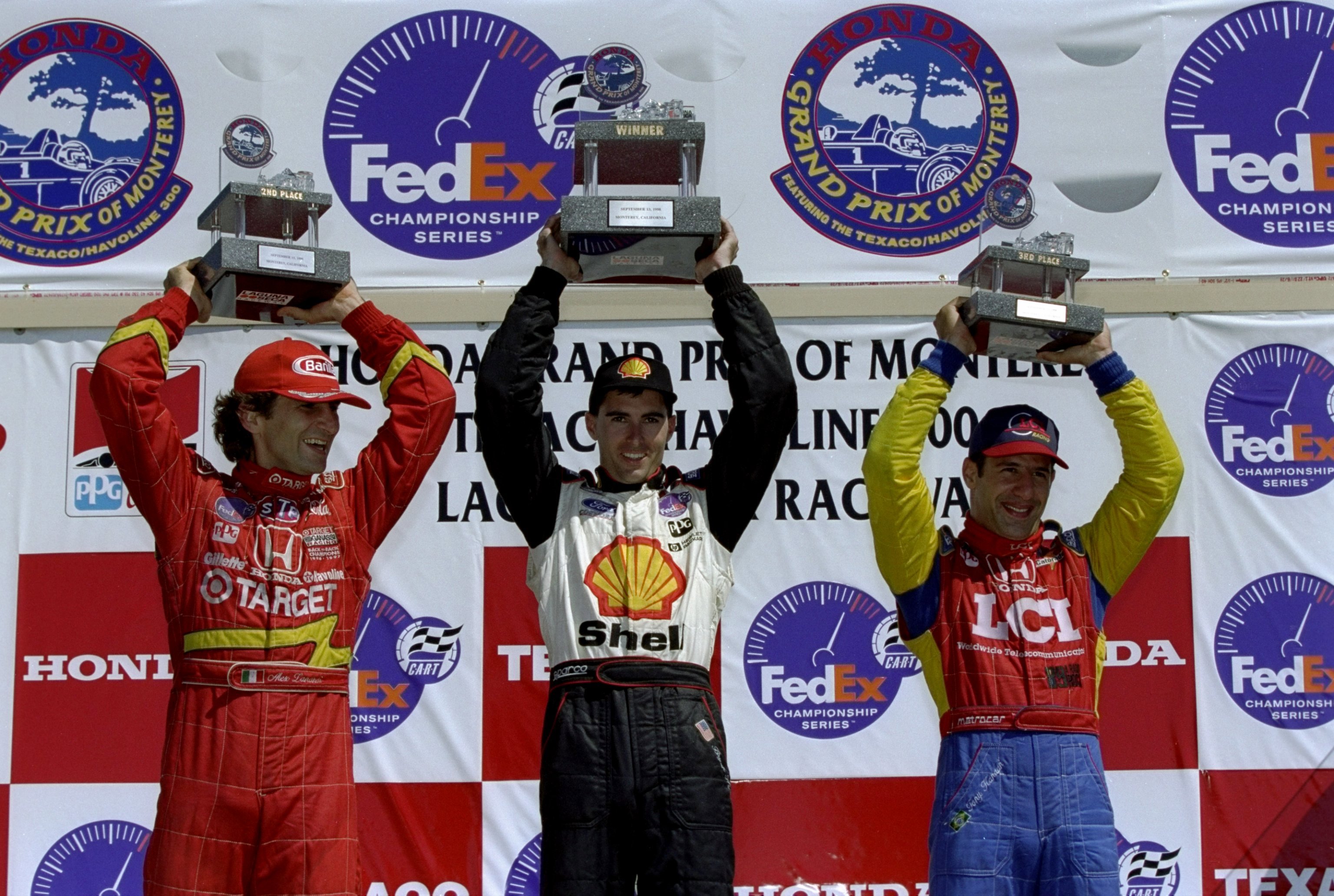 Bryan Herta (centre), Alex Zanardi (left) and Tony Kanann stand on the podium in the 1998 CART race at Laguna Seca.