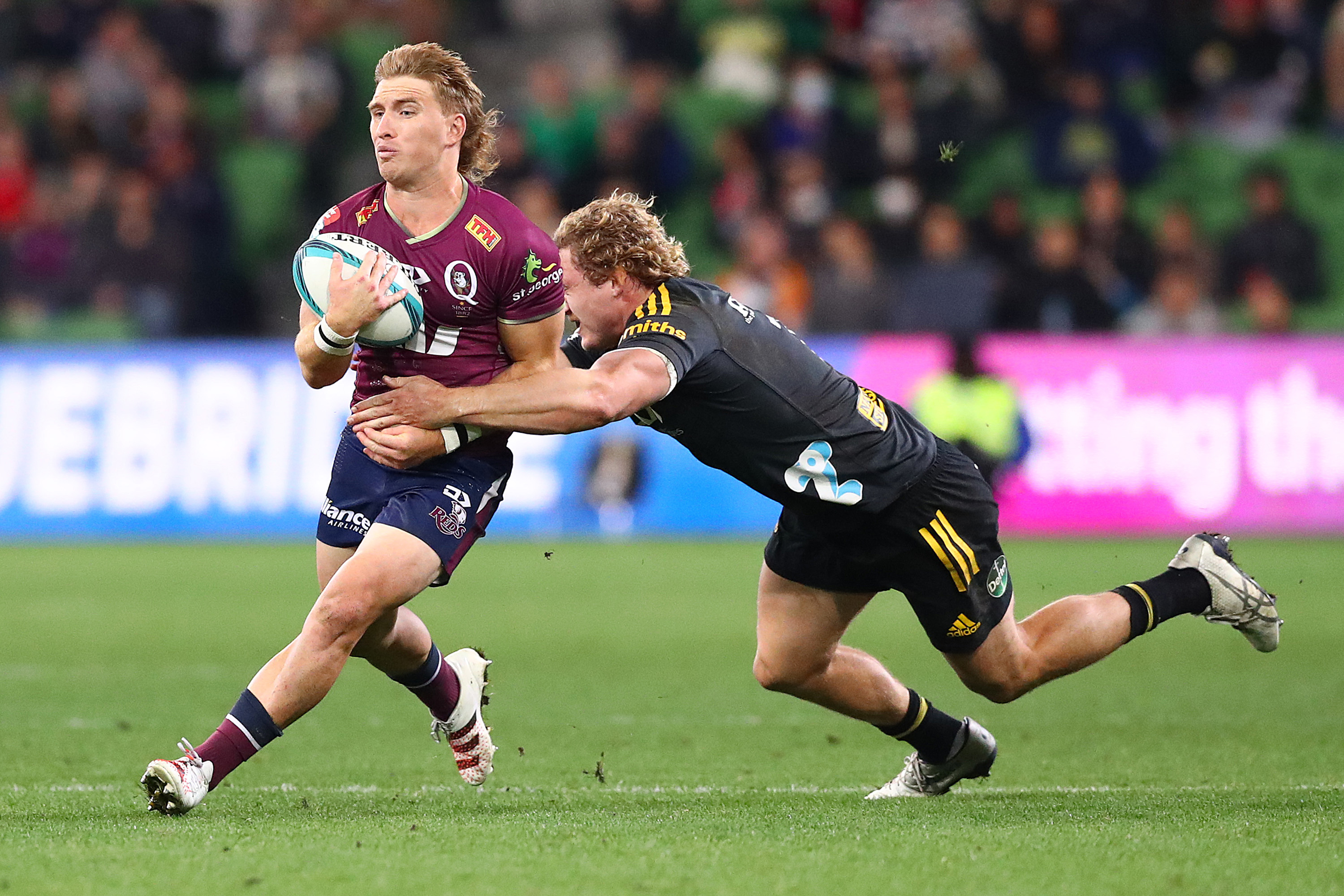 Tate McDermott of the Reds is tackled in a match against the Hurricanes at AAMI Park.