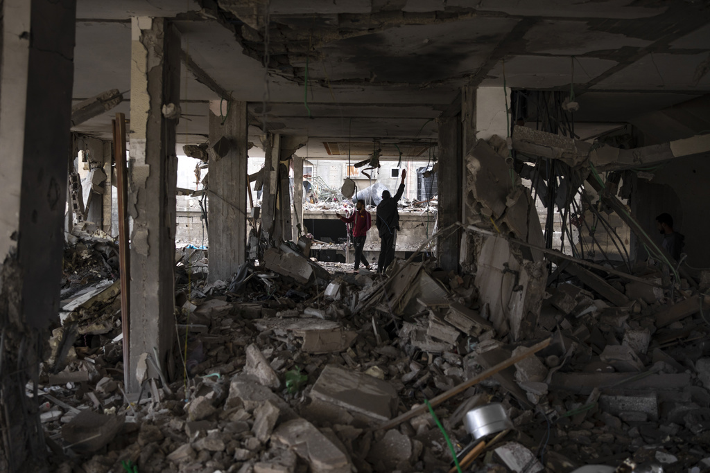 Palestinians look at the destruction after an Israeli airstrike in Rafah, Gaza Strip, Friday, Feb. 9, 2024. 