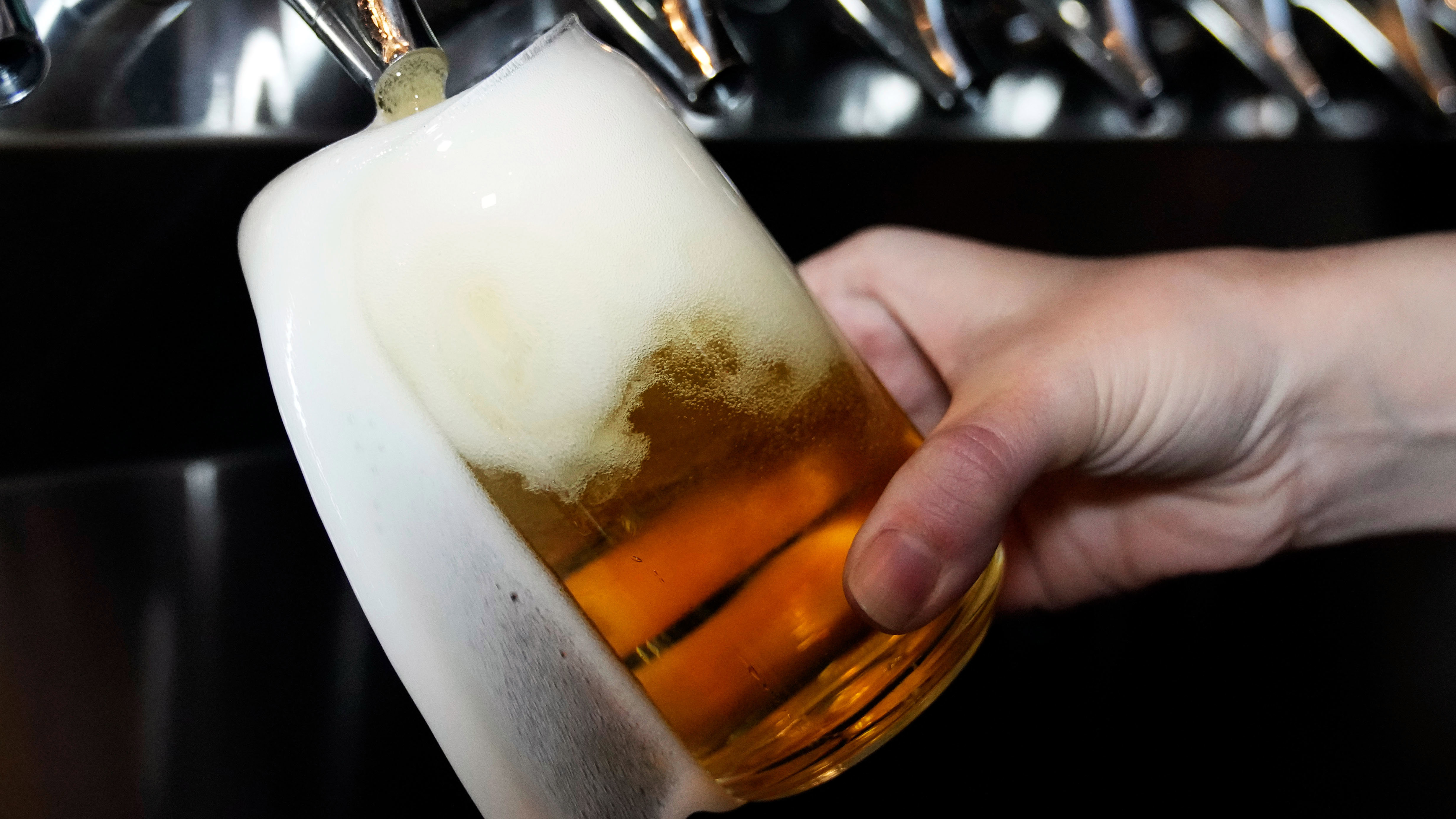 A bartender pours a craft beer.