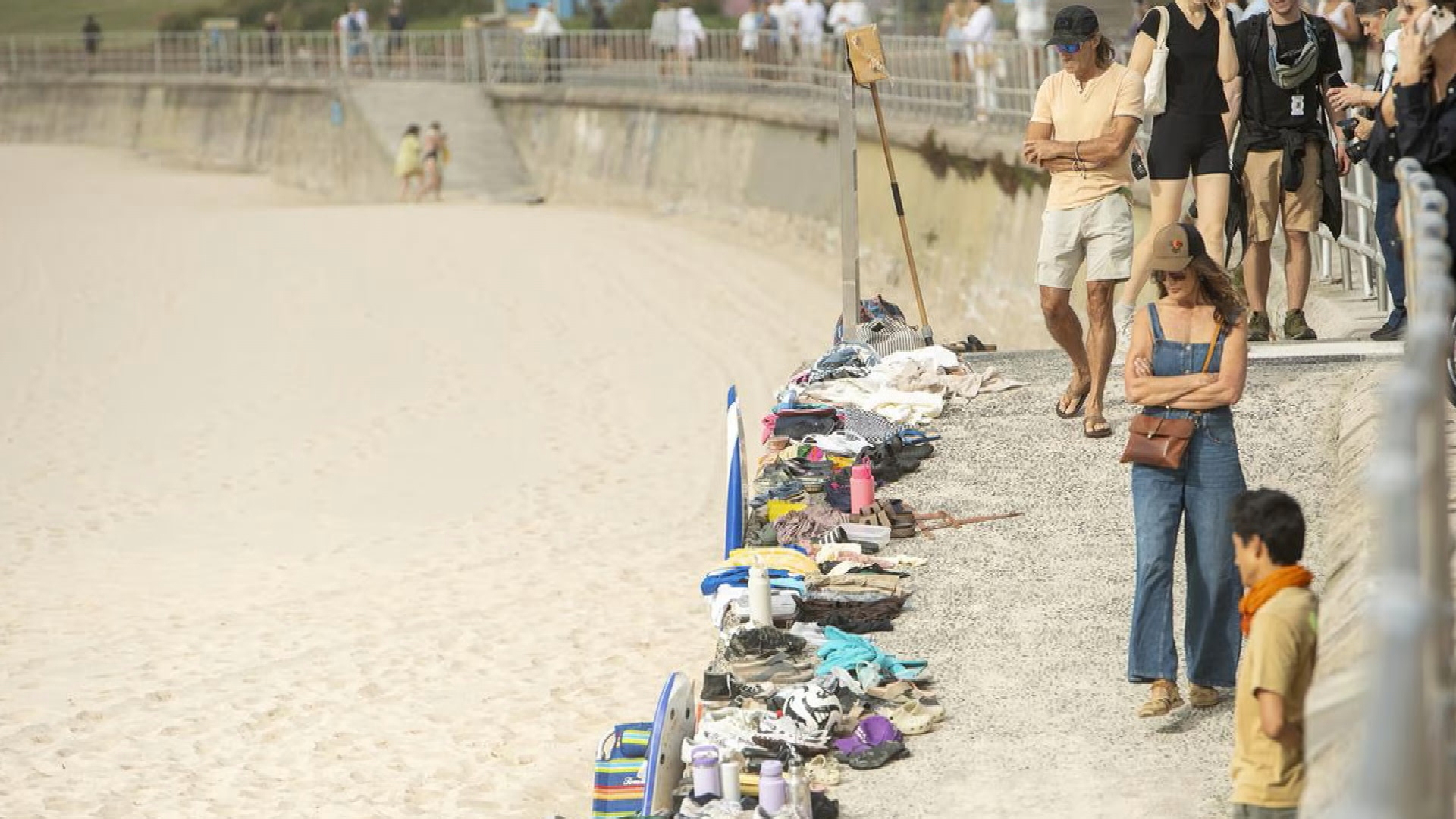 Personal belongings have been left scattered across Bondi Beach, with shoes, bags, children's toys, books and towels still lining the sand after people left them behind to run for their lives.