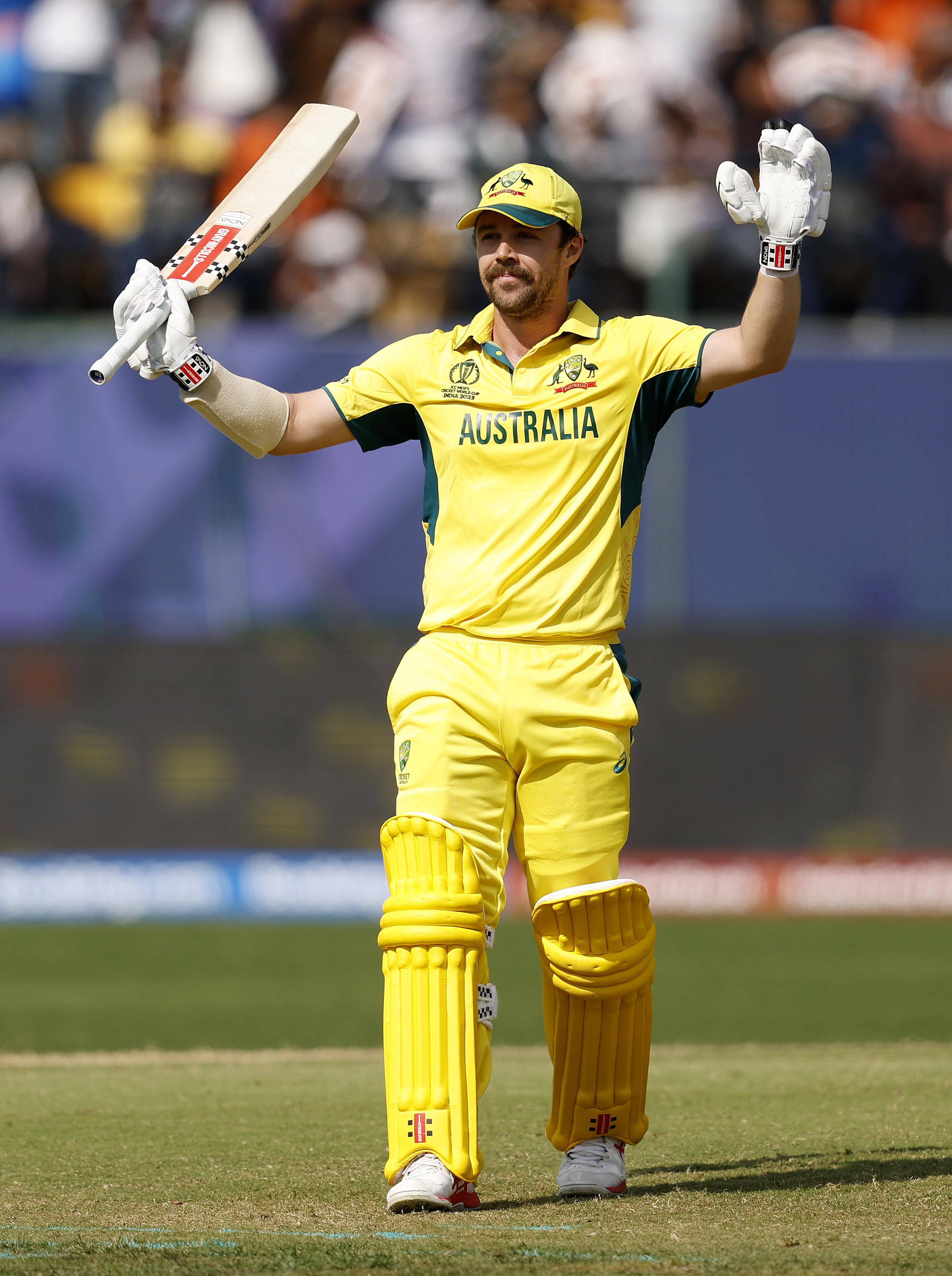 Travis Head of Australia celebrates as he raises his bat after reaching his century after scoring 100.