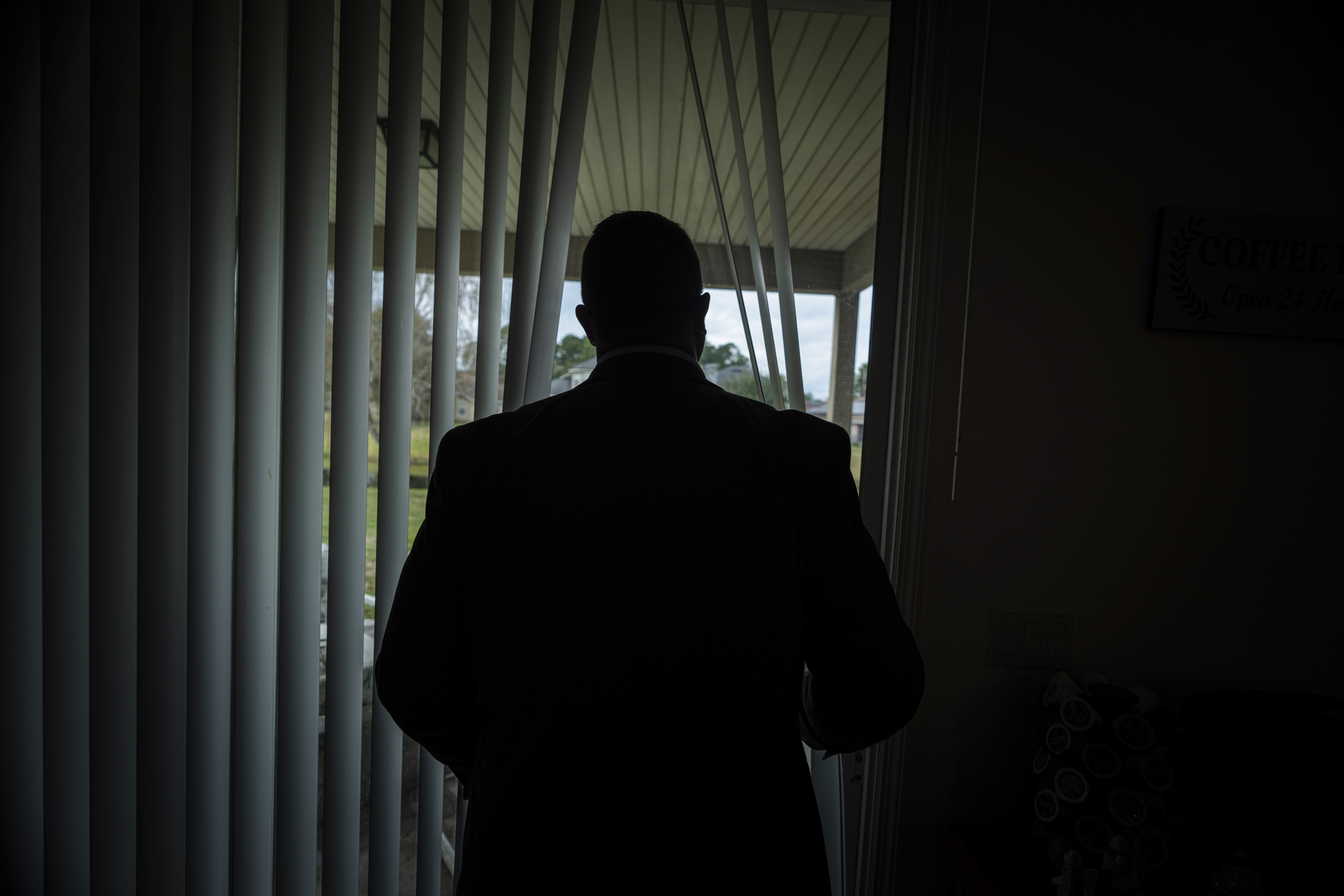 Joseph Moore looks out of a window at his home in Jacksonville, Florida.