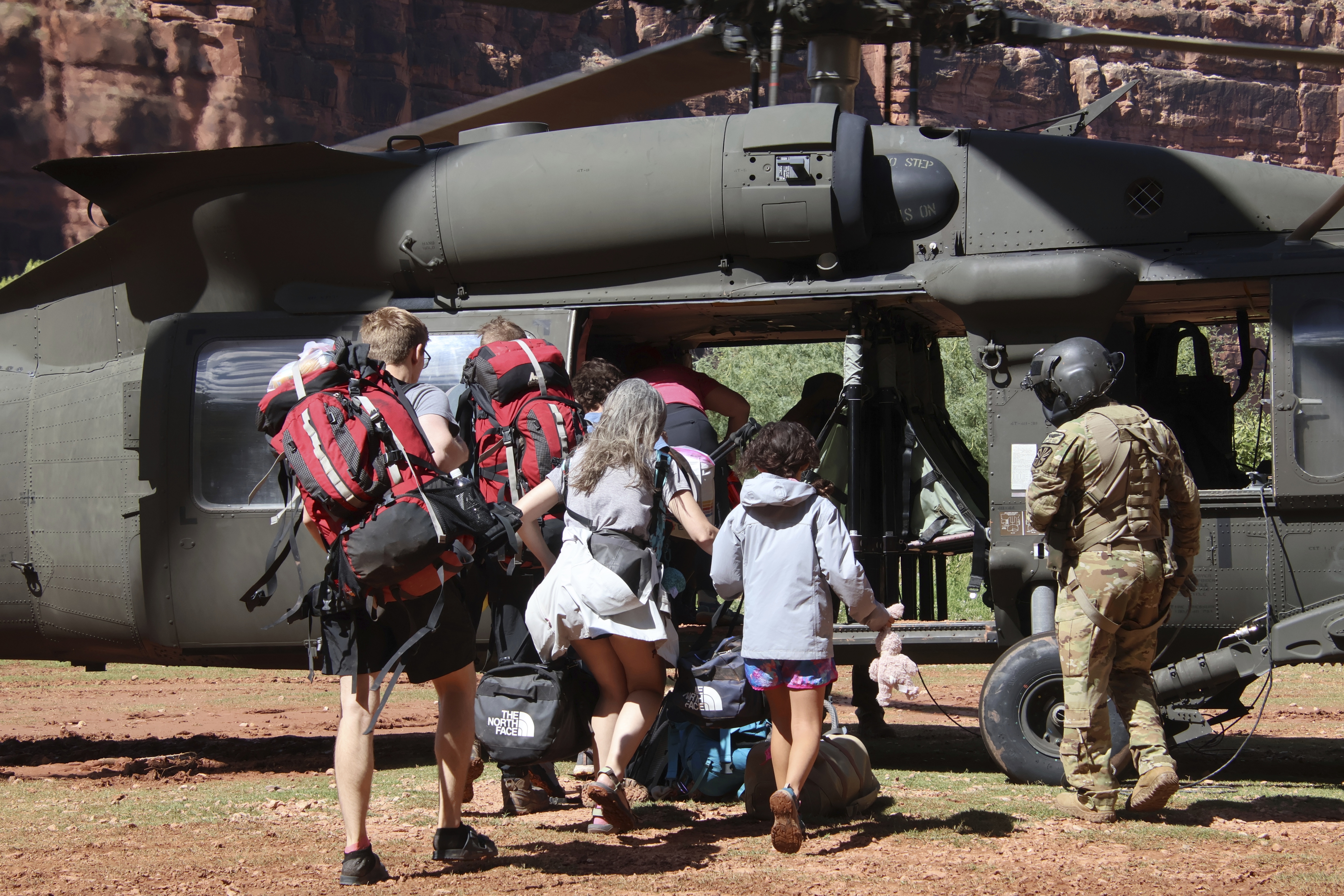 Soldados del Ejército de EE. UU. de la Guardia Nacional de Arizona guían a turistas atrapados por una inundación repentina en un UH-60 Blackhawk el 24 de agosto en la reserva Havasupai en Supai, Arizona.