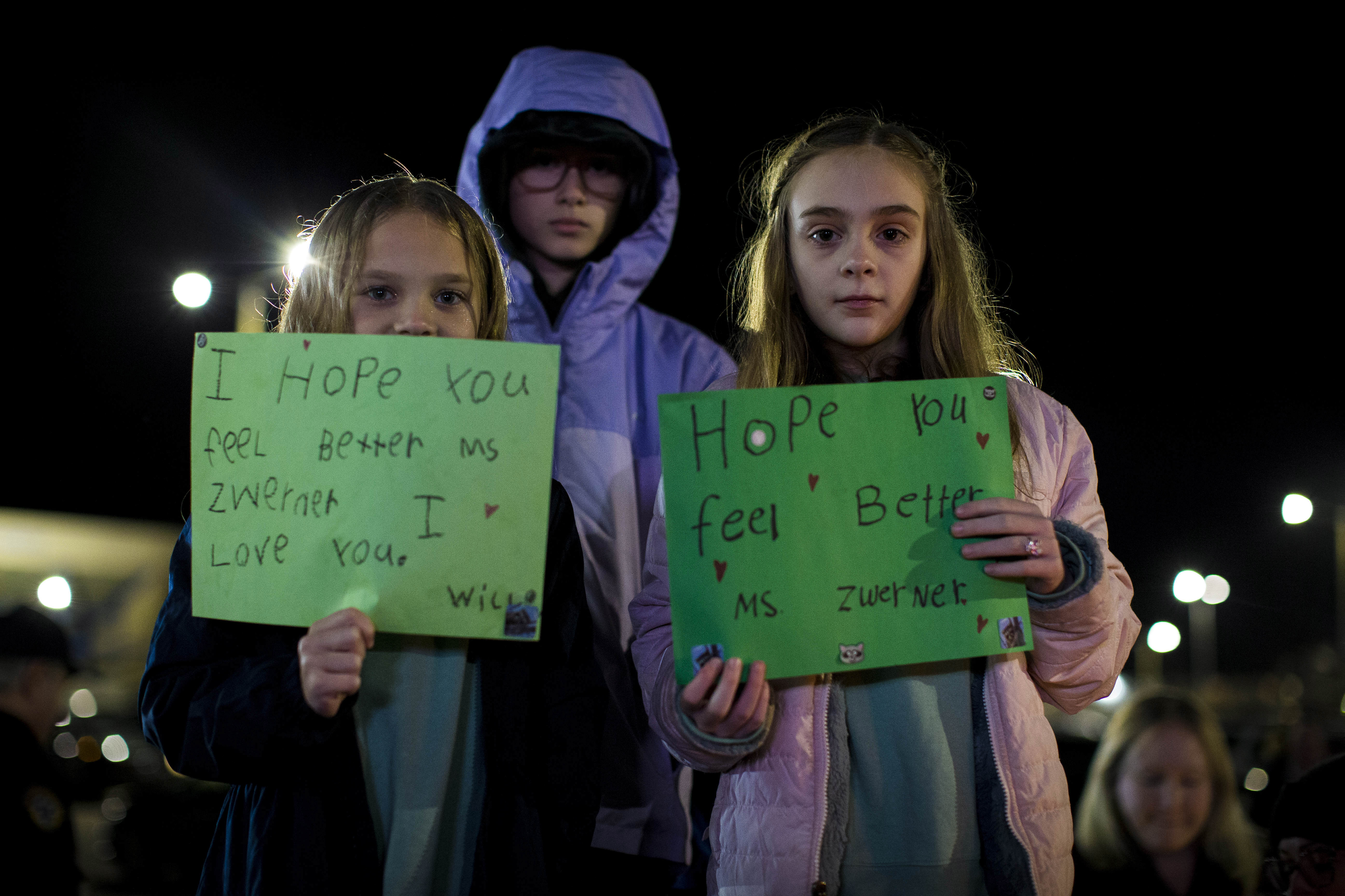Willow Crawford, left, and her older sister Ava, right, join friend Kaylynn Vestre, center, in expressing their support for Richneck Elementary School first-grade teacher Abby Zwerner during a candlelight vigil in her honor at the School Administration Building in Newport News, Va., Monday, Jan. 9, 2023.  