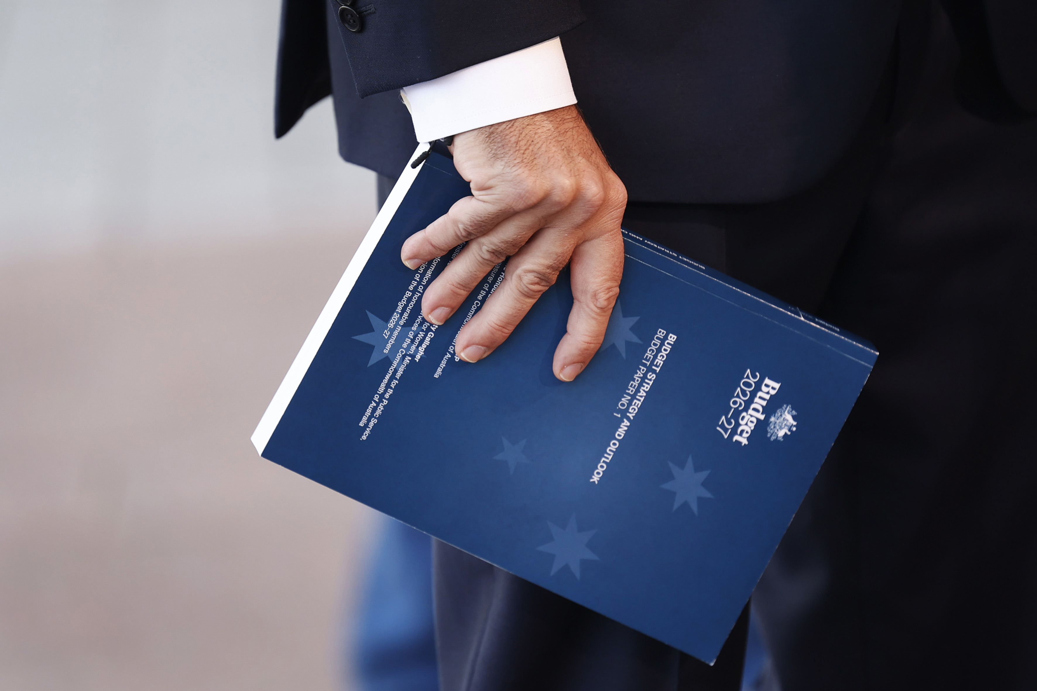 Treasurer Jim Chalmers holds a copy of the 2026 budget while speaking with the media at Australian Parliament House on May 12, 2026 in Canberra, Australia. 