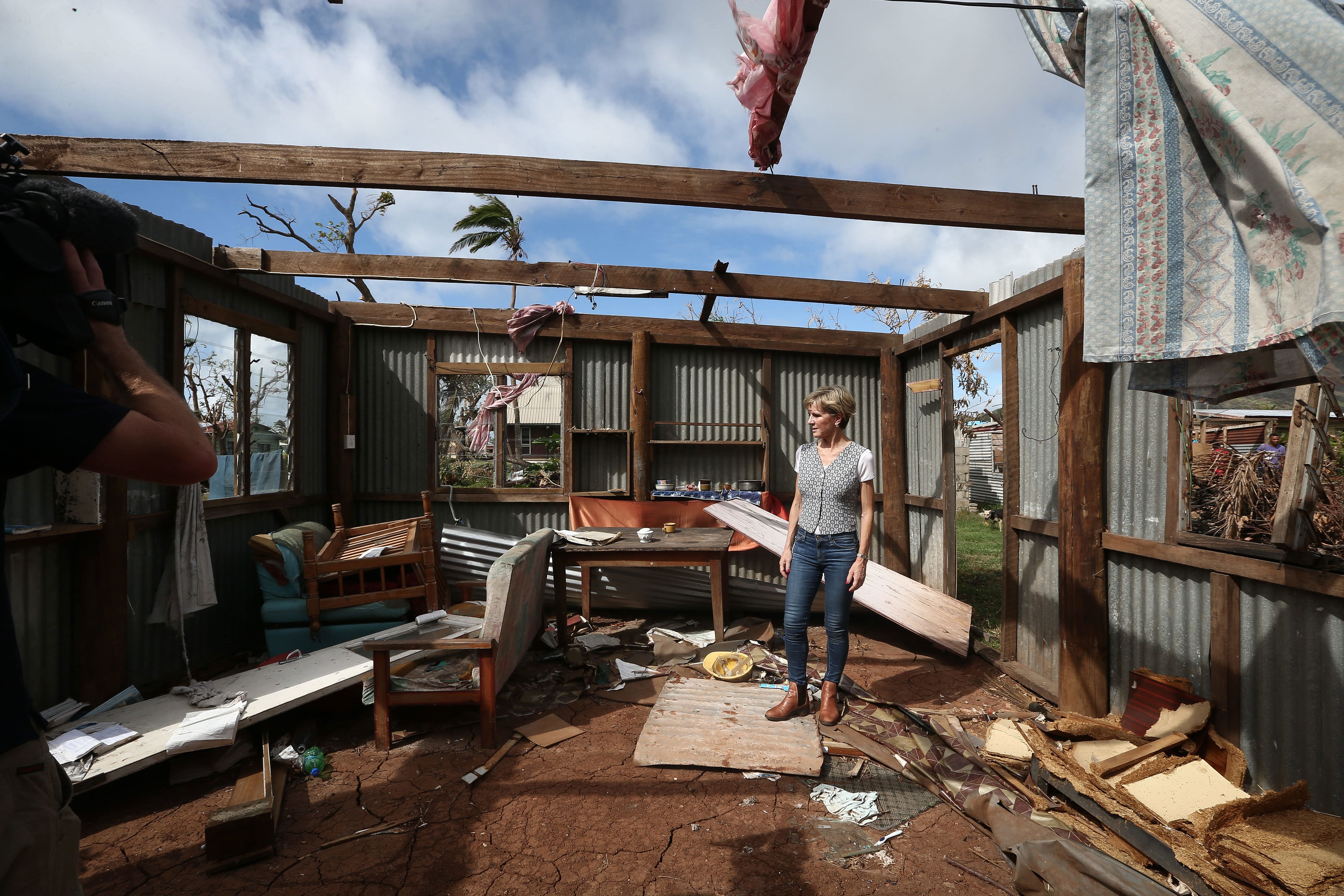 Australia's then-Foreign Minister Julie Bishop walks through a house destroyed by Cyclone Winston in 2016.