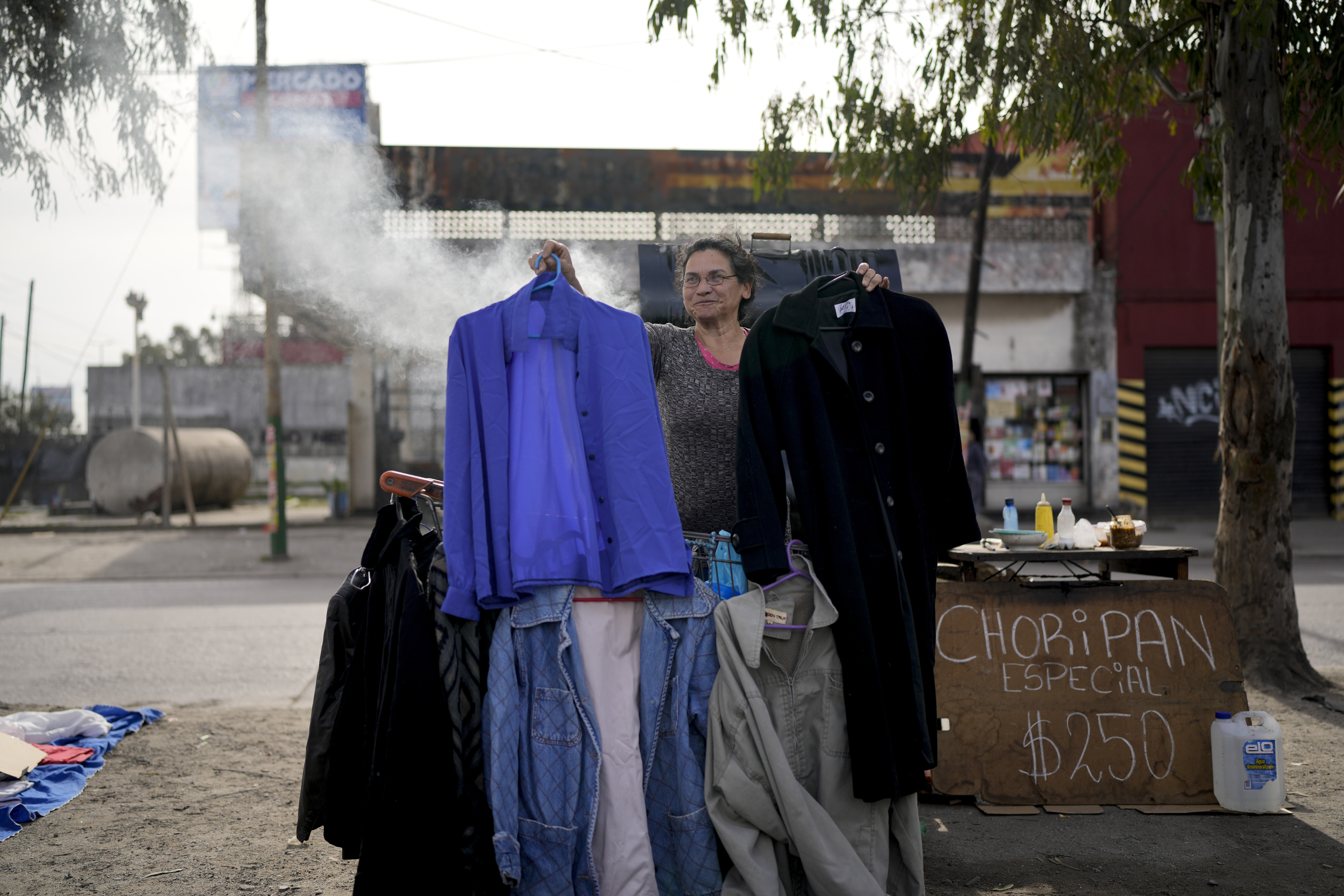 A vendor holds up secondhand garments.