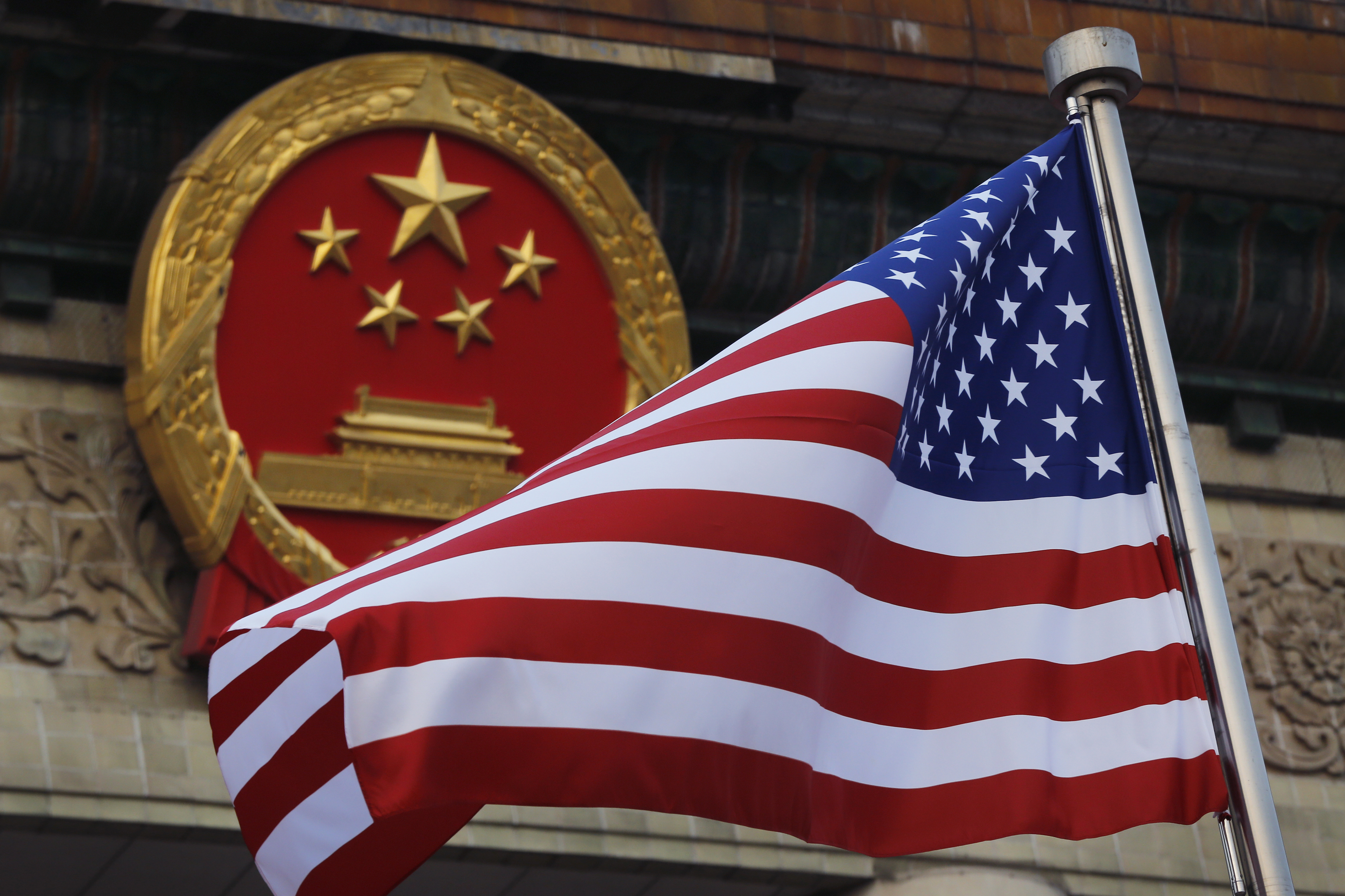 Una bandera estadounidense ondea junto al emblema nacional chino durante una ceremonia de bienvenida en el Gran Salón del Pueblo en Beijing, el 9 de noviembre de 2017.  