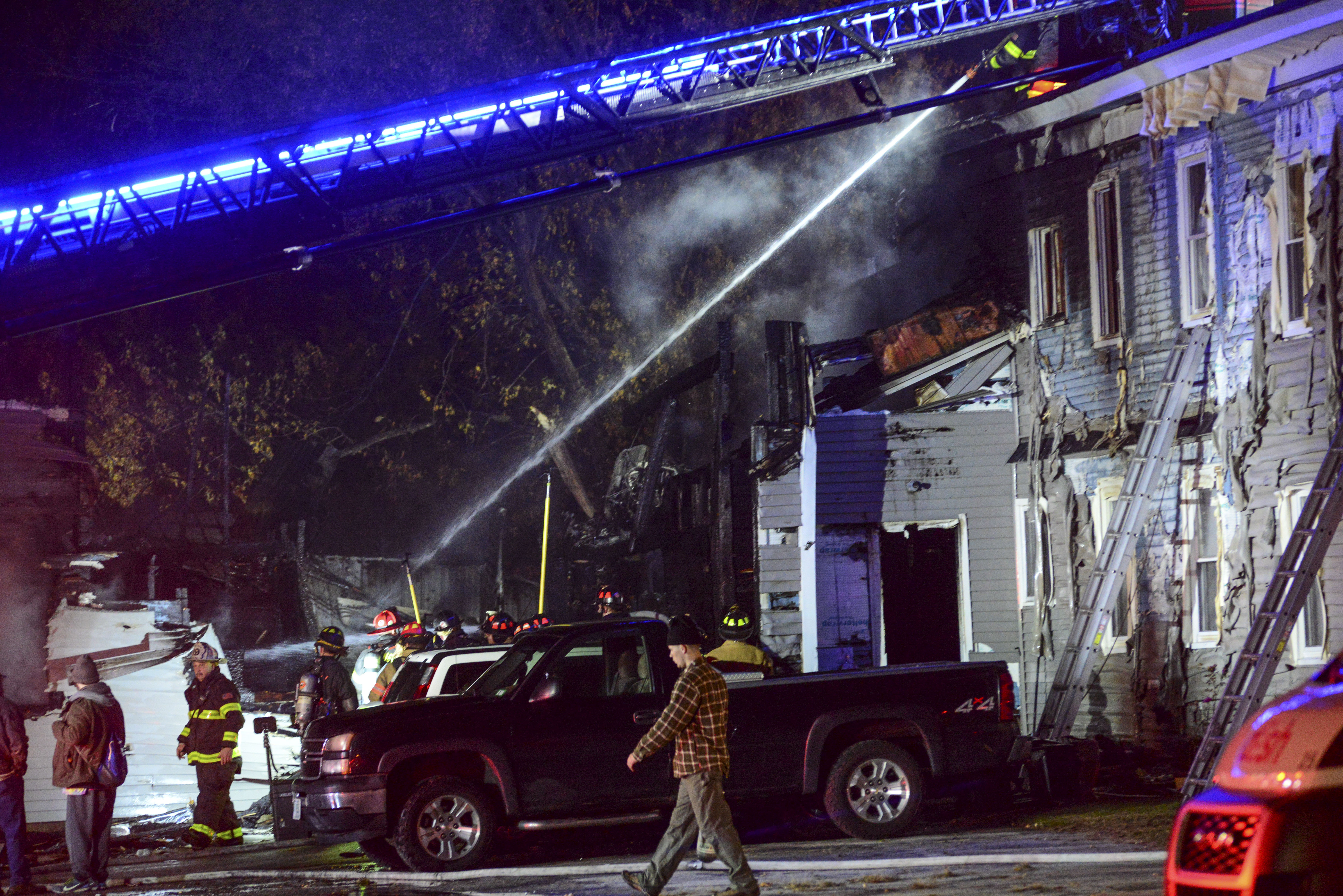 Firefighters work to extinguish a fire in a building after a single-engine plane crashed nearby in Keene, N.H., Friday, Oct. 21, 2022.  