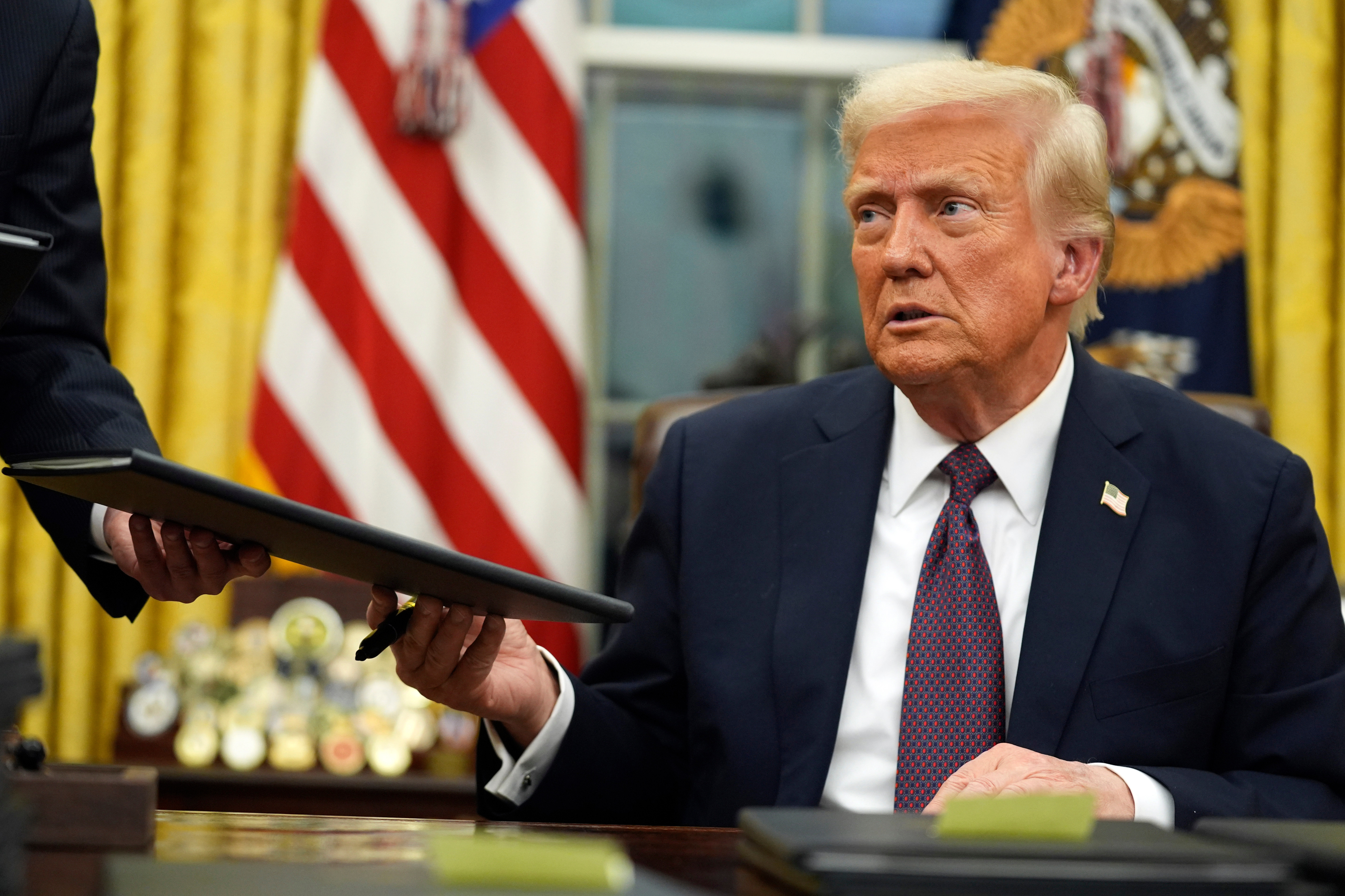 President Donald Trump signs executive orders in the Oval Office of the White House, Jan. 20, 2025, in Washington.