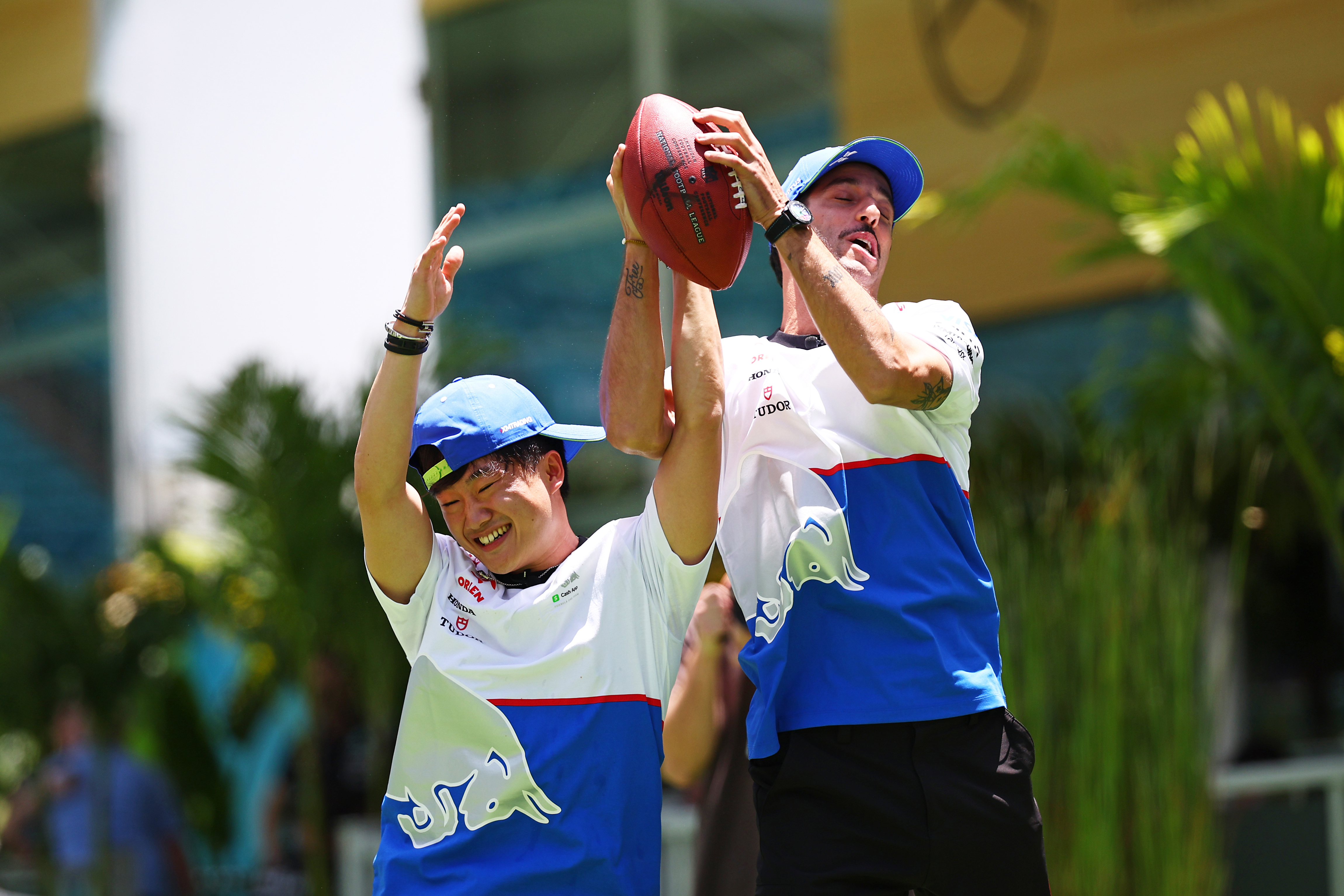 Daniel Ricciardo of Australia and Visa Cash App RB and Yuki Tsunoda of Japan and Visa Cash App RB compete for a catch as the play football in the Paddock during previews ahead of the F1 Grand Prix of Miami at Miami International Autodrome on May 02, 2024 in Miami, Florida. (Photo by Jared C. Tilton - Formula 1/Formula 1 via Getty Images)