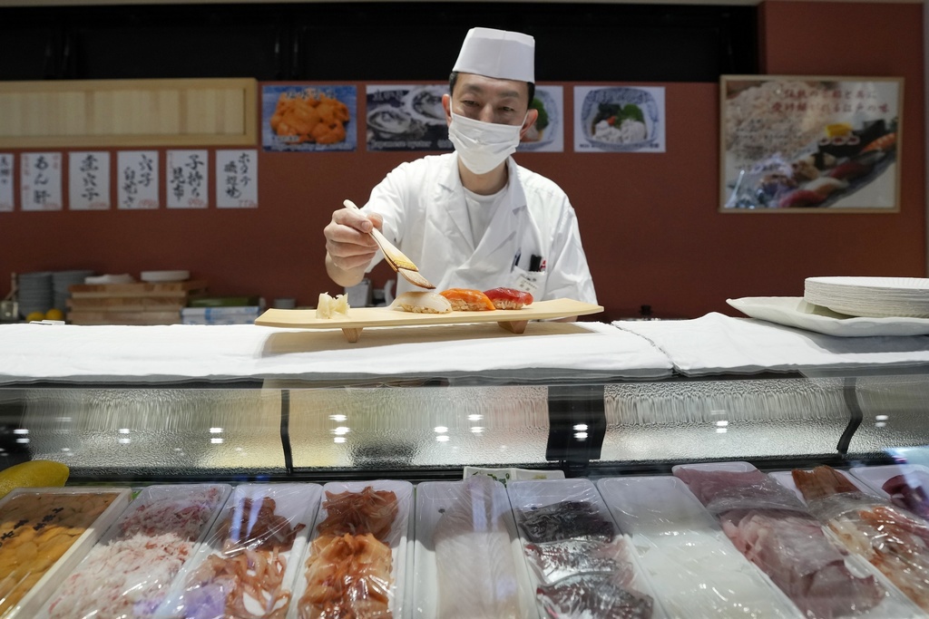 ARCHIVO - Un chef de sushi prepara un plato en el mercado Toyosu el lunes 29 de enero de 2024 en Tokio.  Japón ha caído a la cuarta economía más grande del mundo, ya que los datos gubernamentales publicados el jueves 14 de febrero de 2024 mostraron que se quedó atrás del tamaño de Alemania en 2023. (Foto AP/Eugene Hoshiko, archivo)