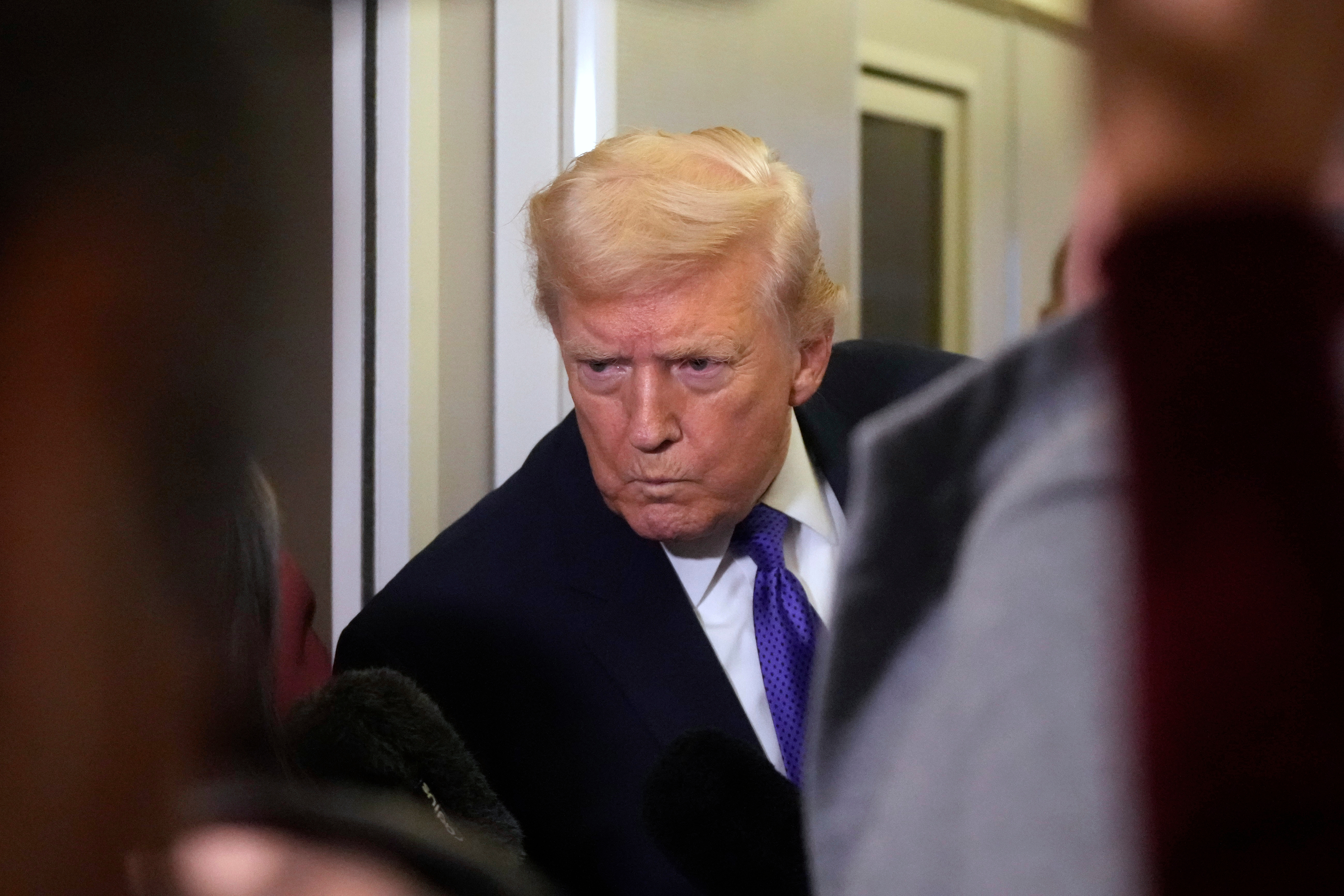 President Donald Trump listens to a reporter's question as he flies aboard Air Force One from Joint Base Andrews, Md., to West Palm Beach, Fla., Friday, Feb. 6, 2026