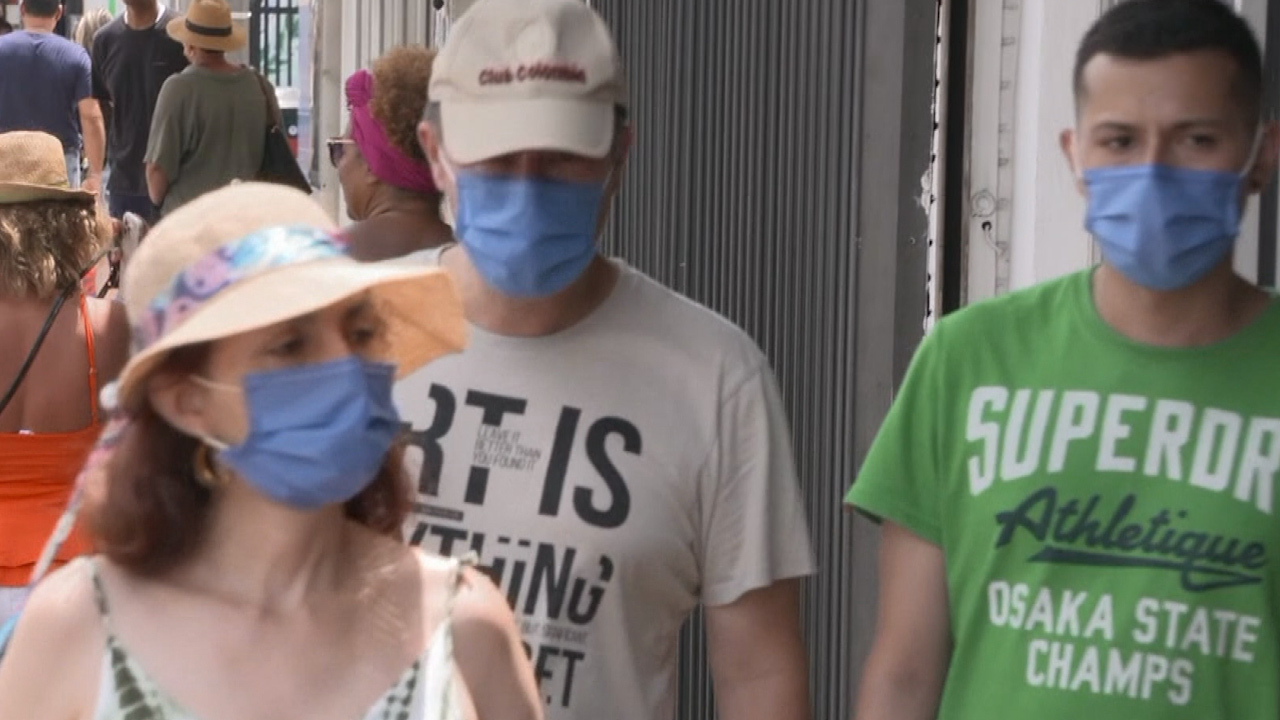 Three individuals wearing face masks in the US.