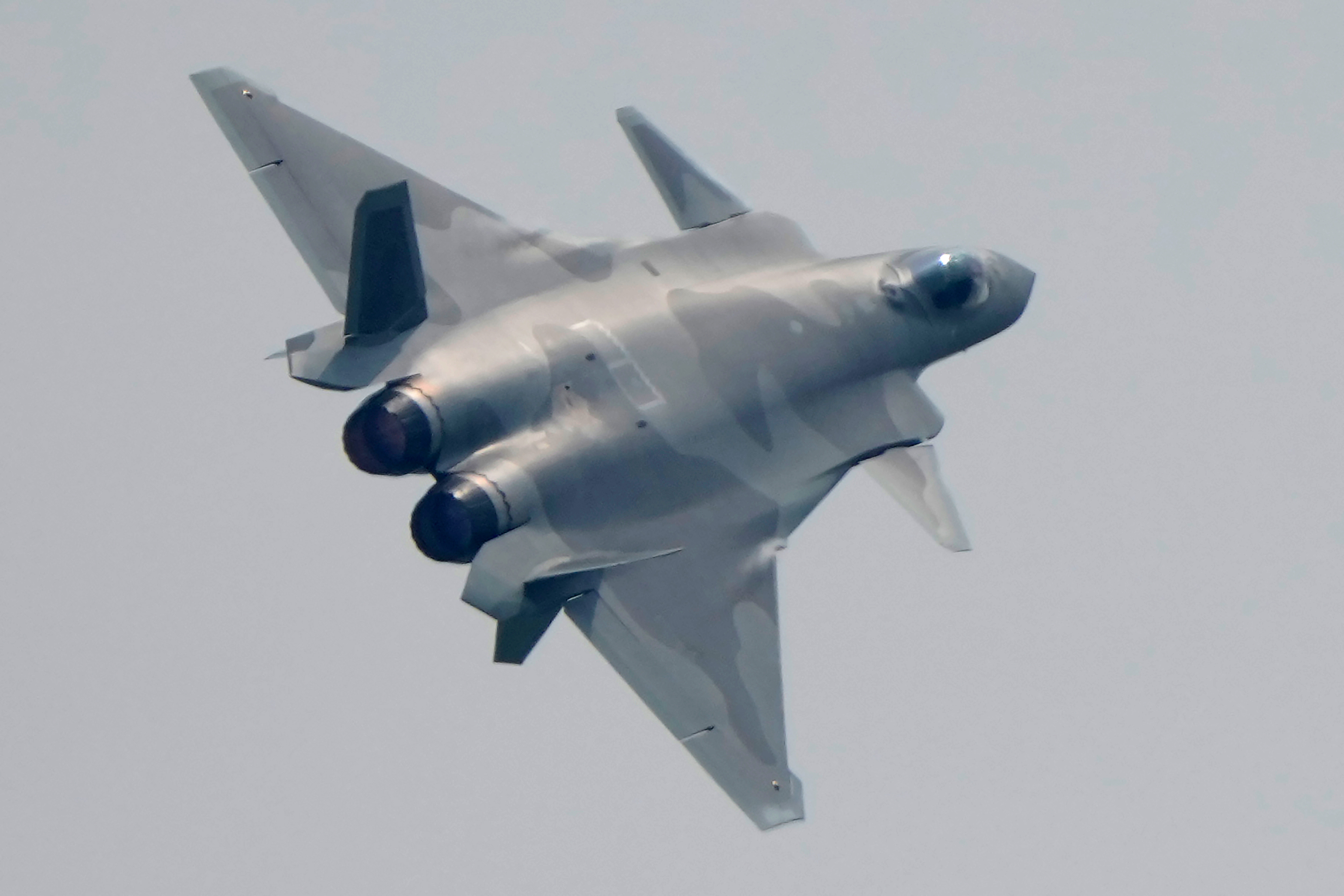 A J-20 stealth fighter jet screams above crowds at the 2021 Airshow China.