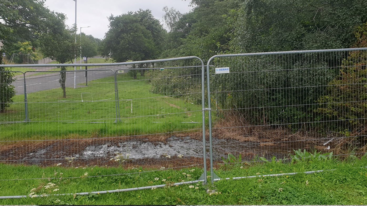 The puddle has been fenced off as the land has become 'completely saturated with an unidentified liquid'.